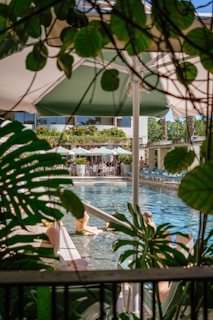 People relaxing by a tropical resort swimming pool.