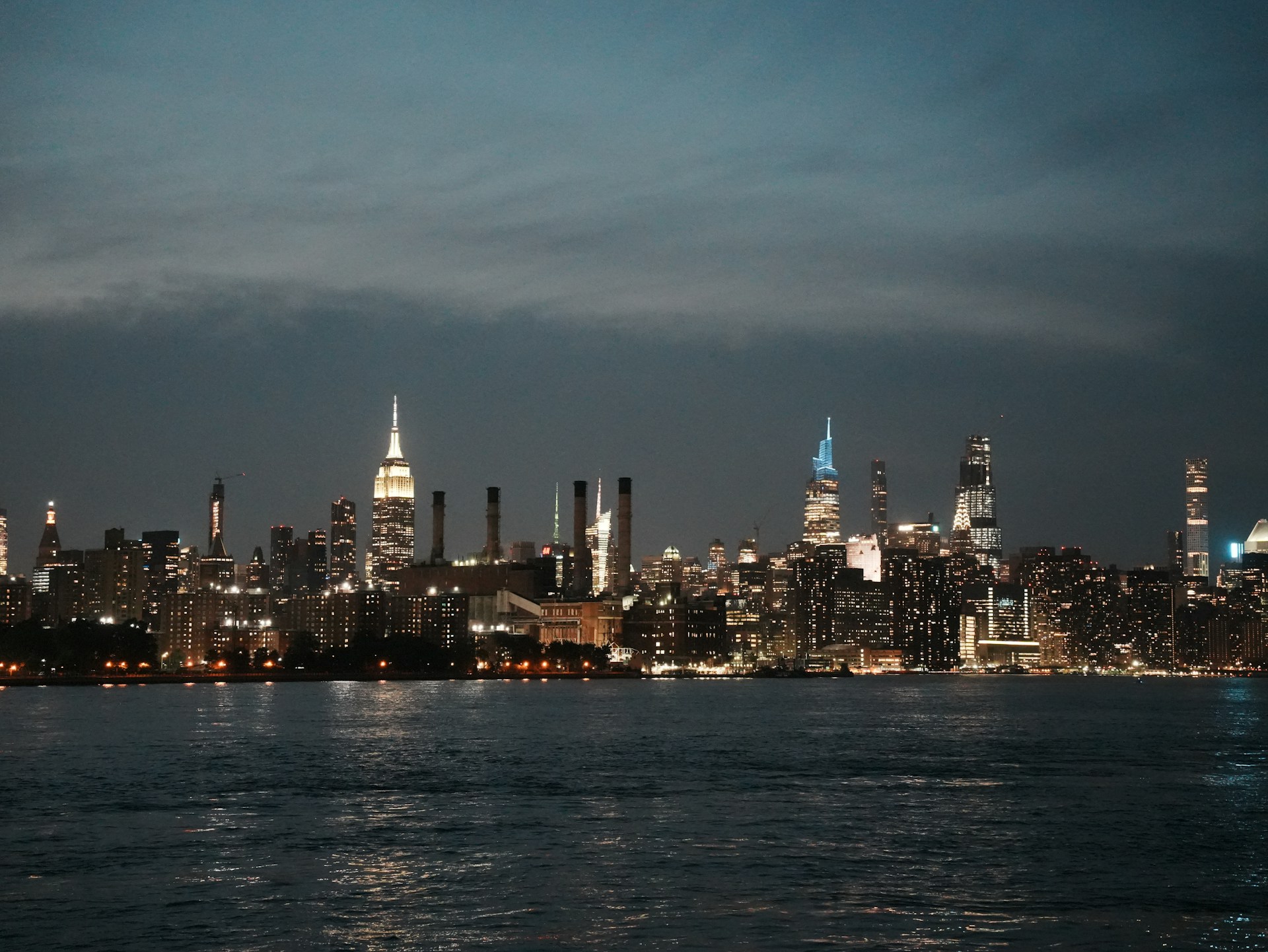 City skyline illuminated at night across the water.