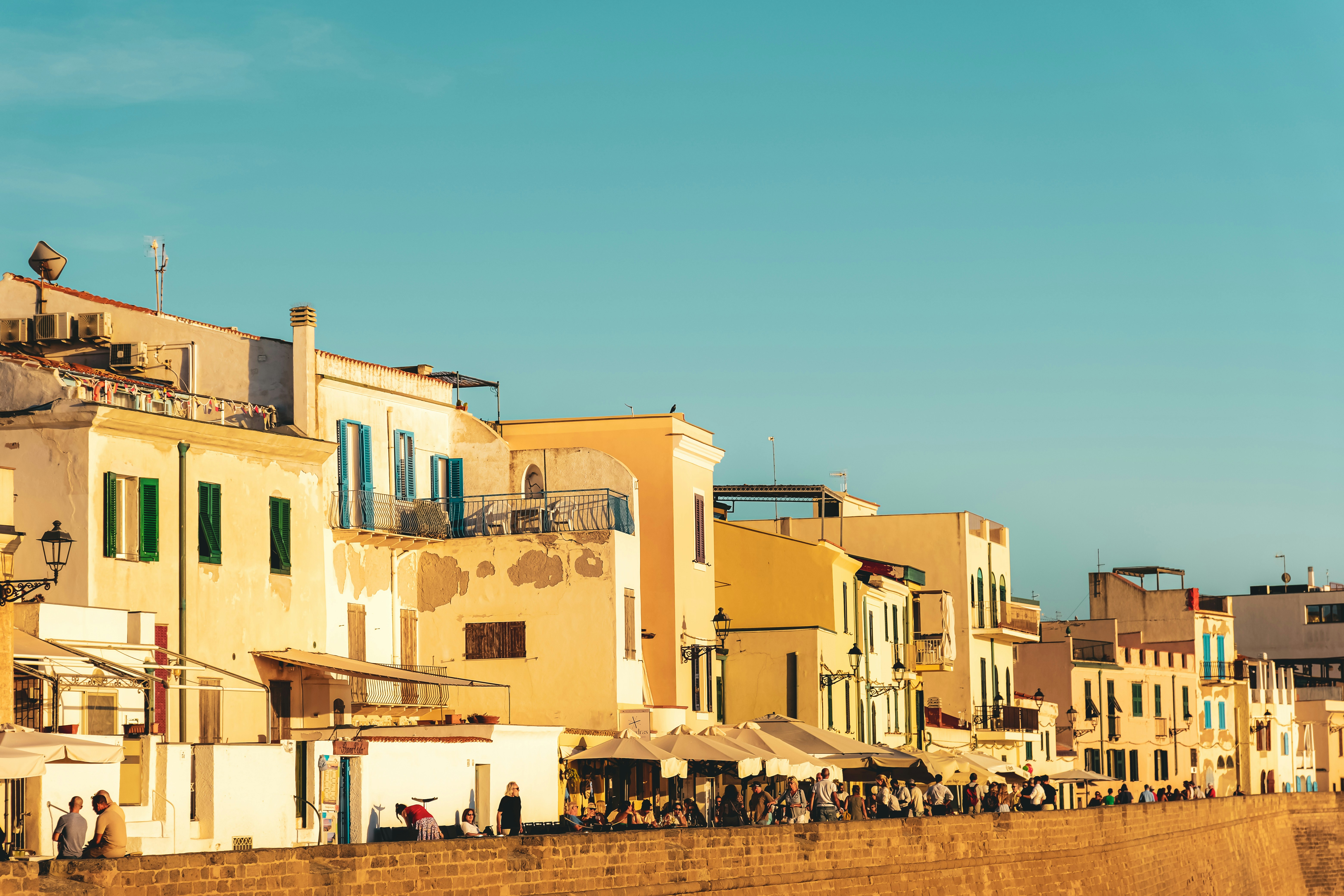 Row of colorful buildings along a sunny coastline.