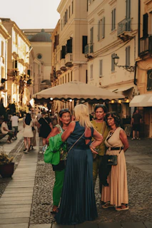Four women talking on a cobblestone street.