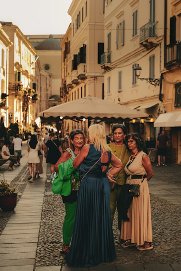 Four women talking on a cobblestone street.