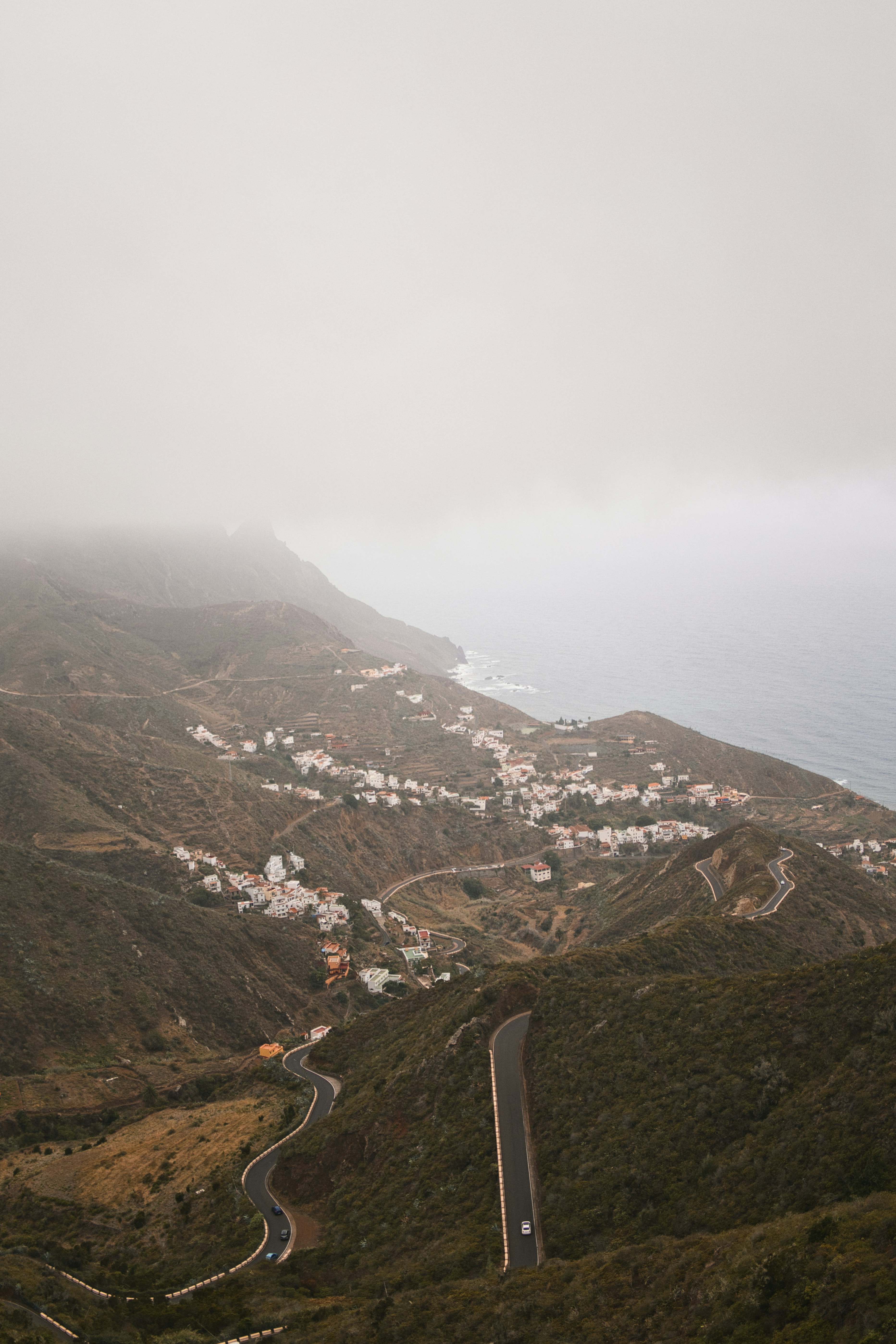 Winding road through a coastal village in fog.
