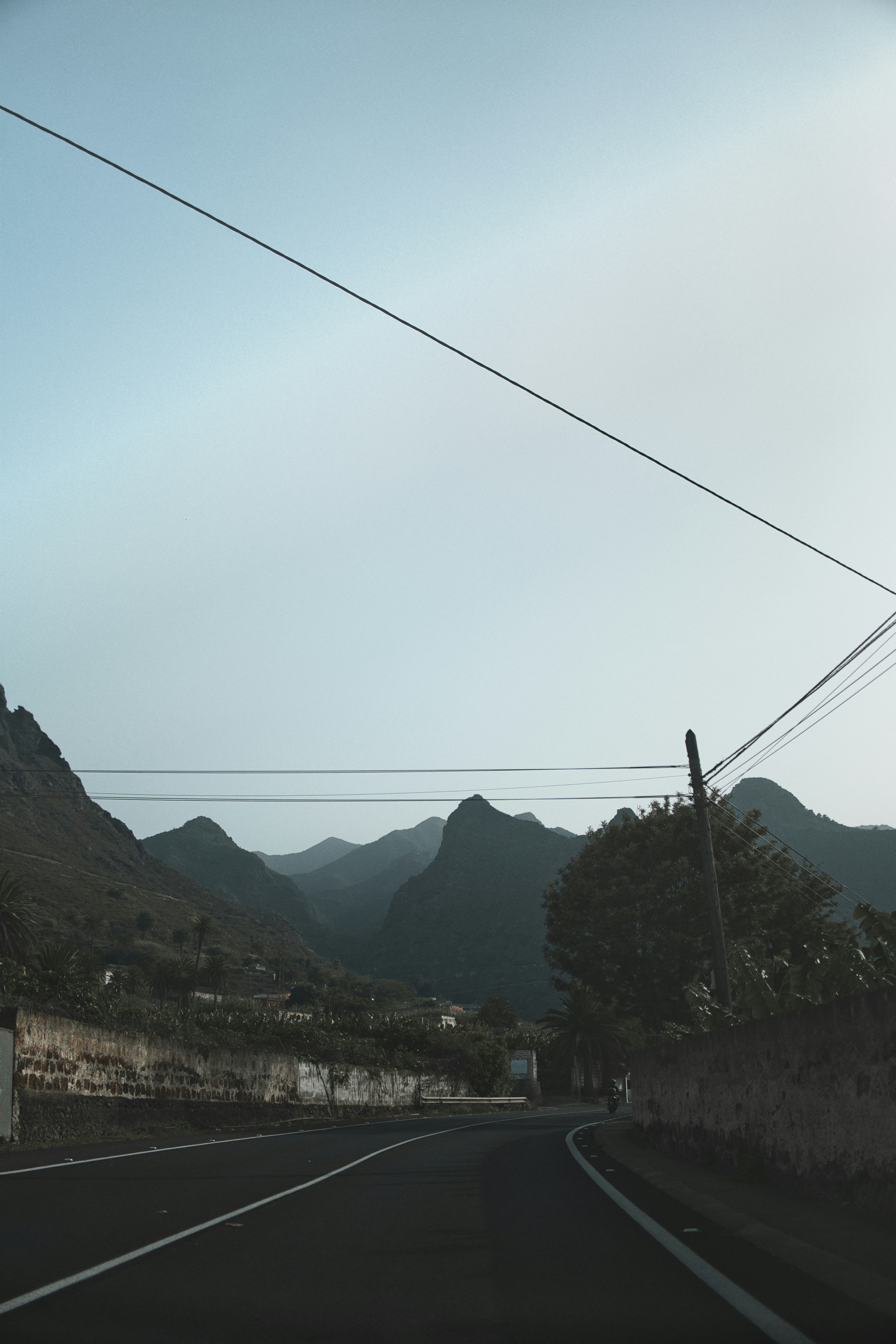 Winding road through a mountainous landscape under a clear sky.