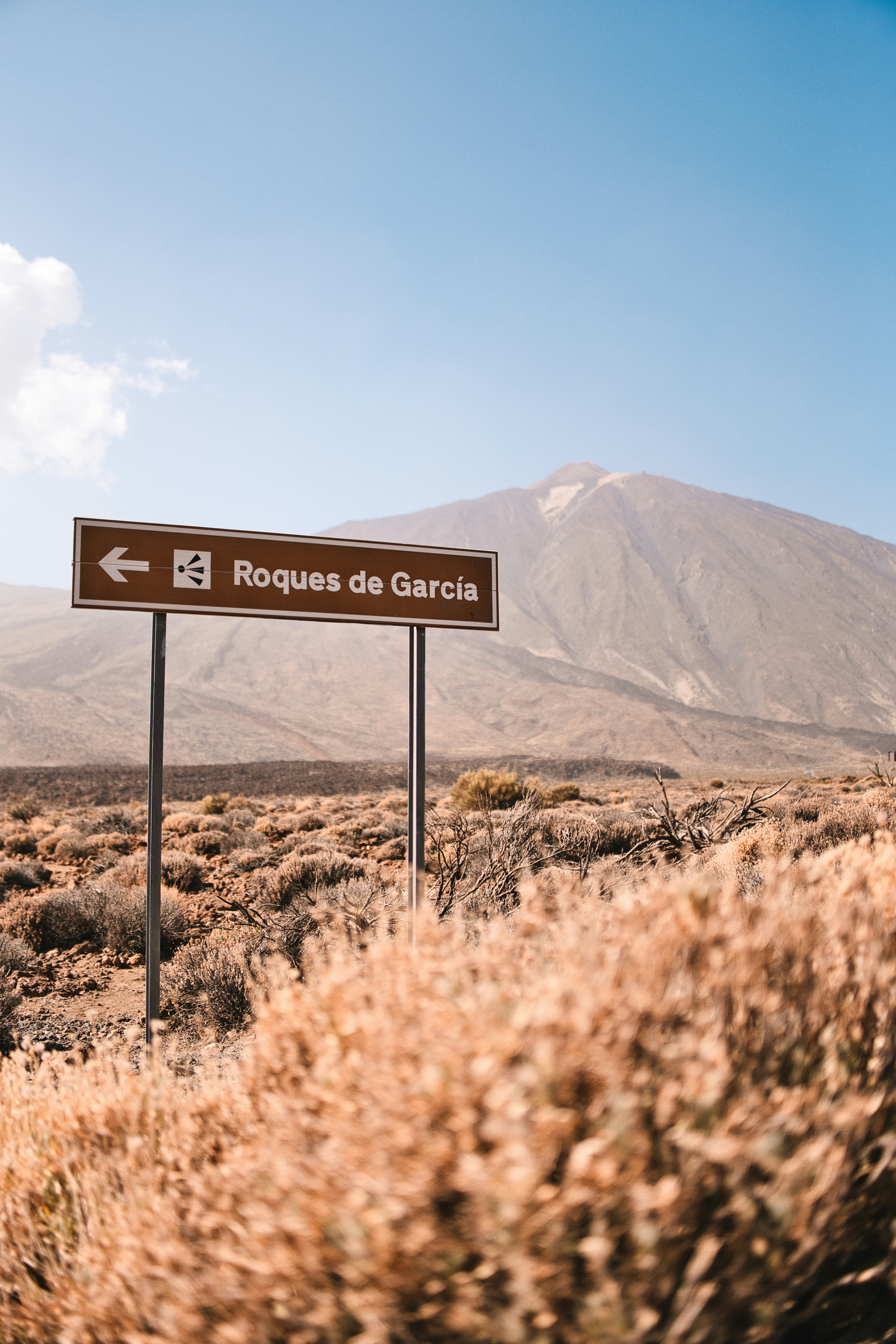 Signpost pointing to roques de garcia with mountain background.