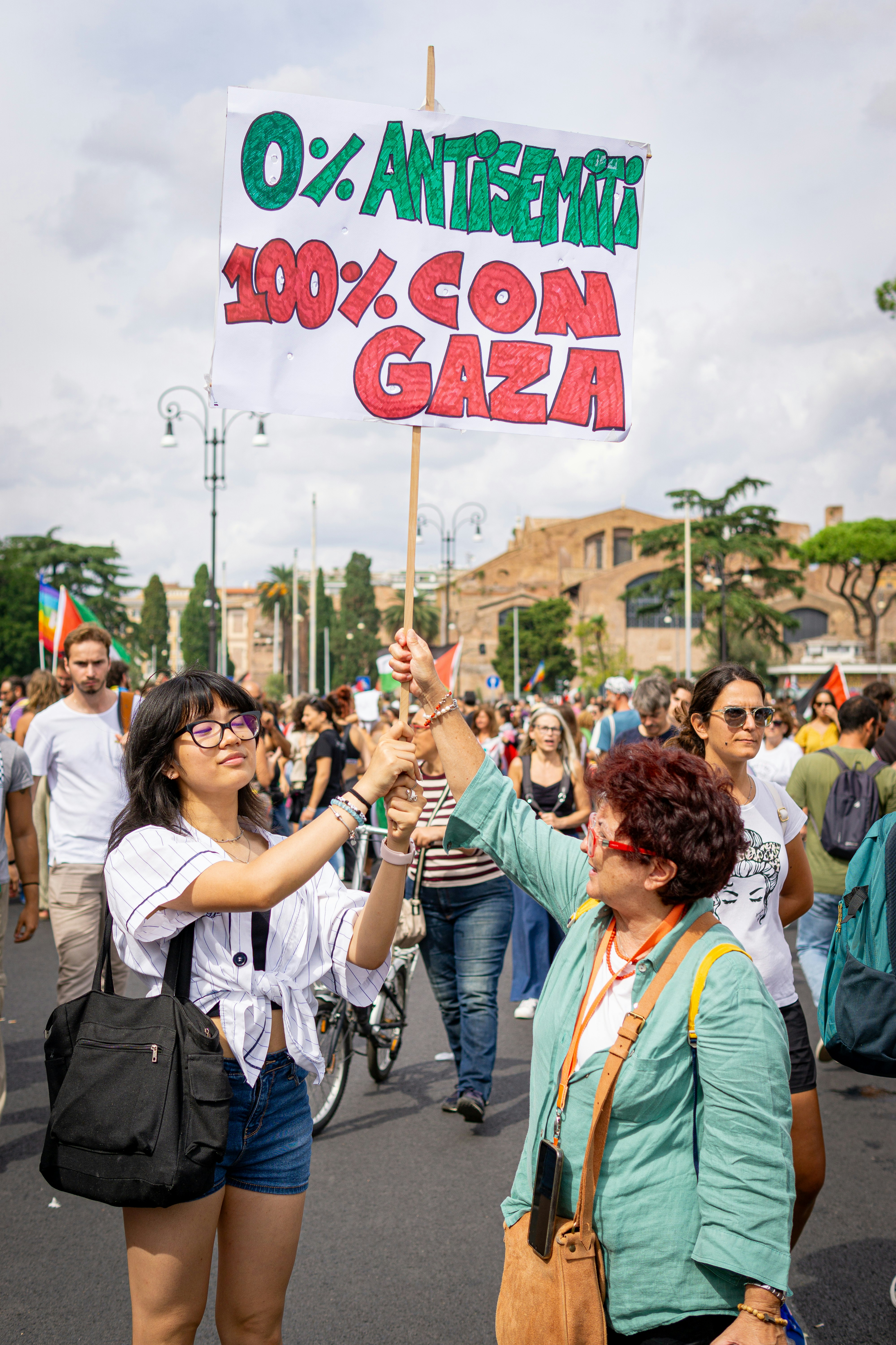 Two women hold a sign supporting gaza at a protest.