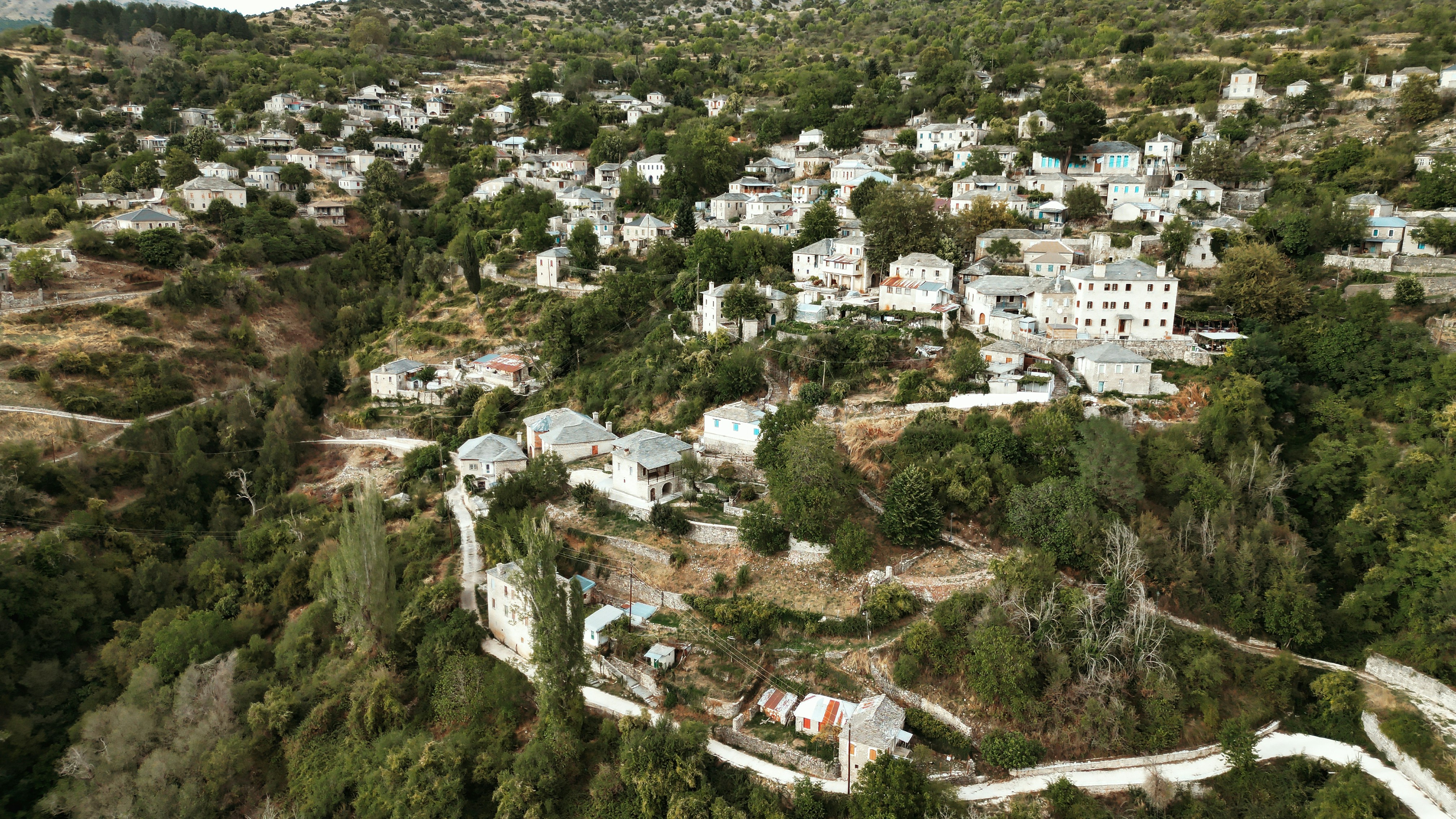 Aerial view of a village nestled among green hills.