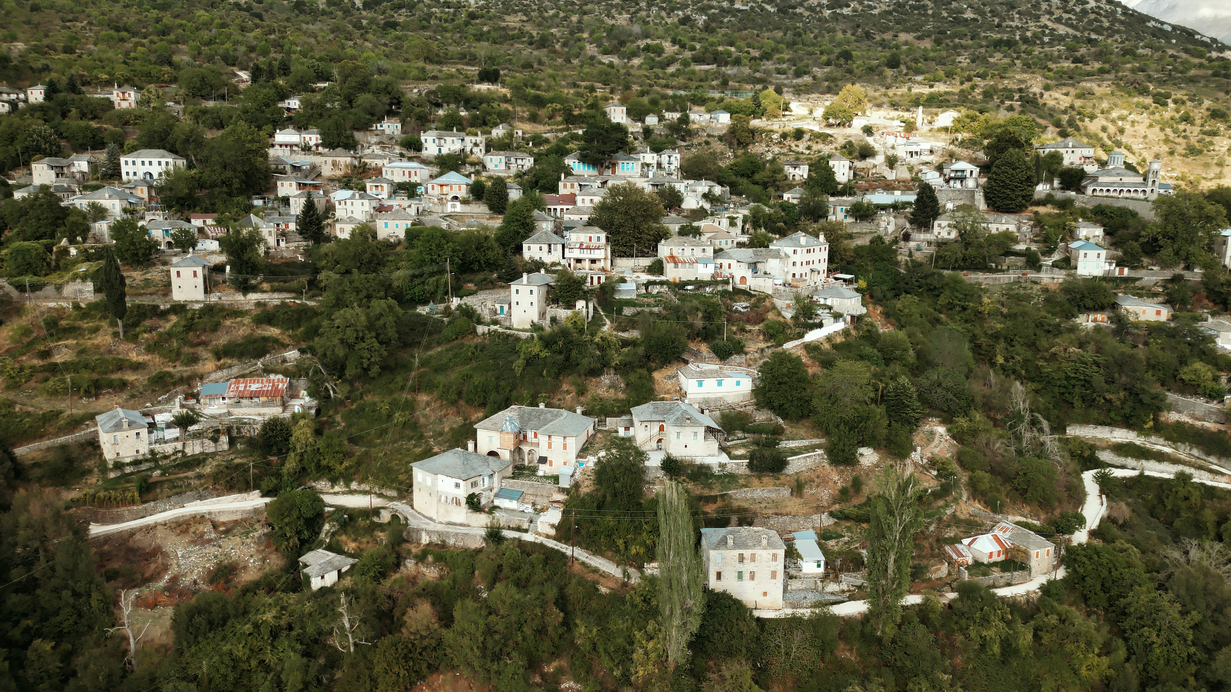 Aerial view of a village nestled in green hills.