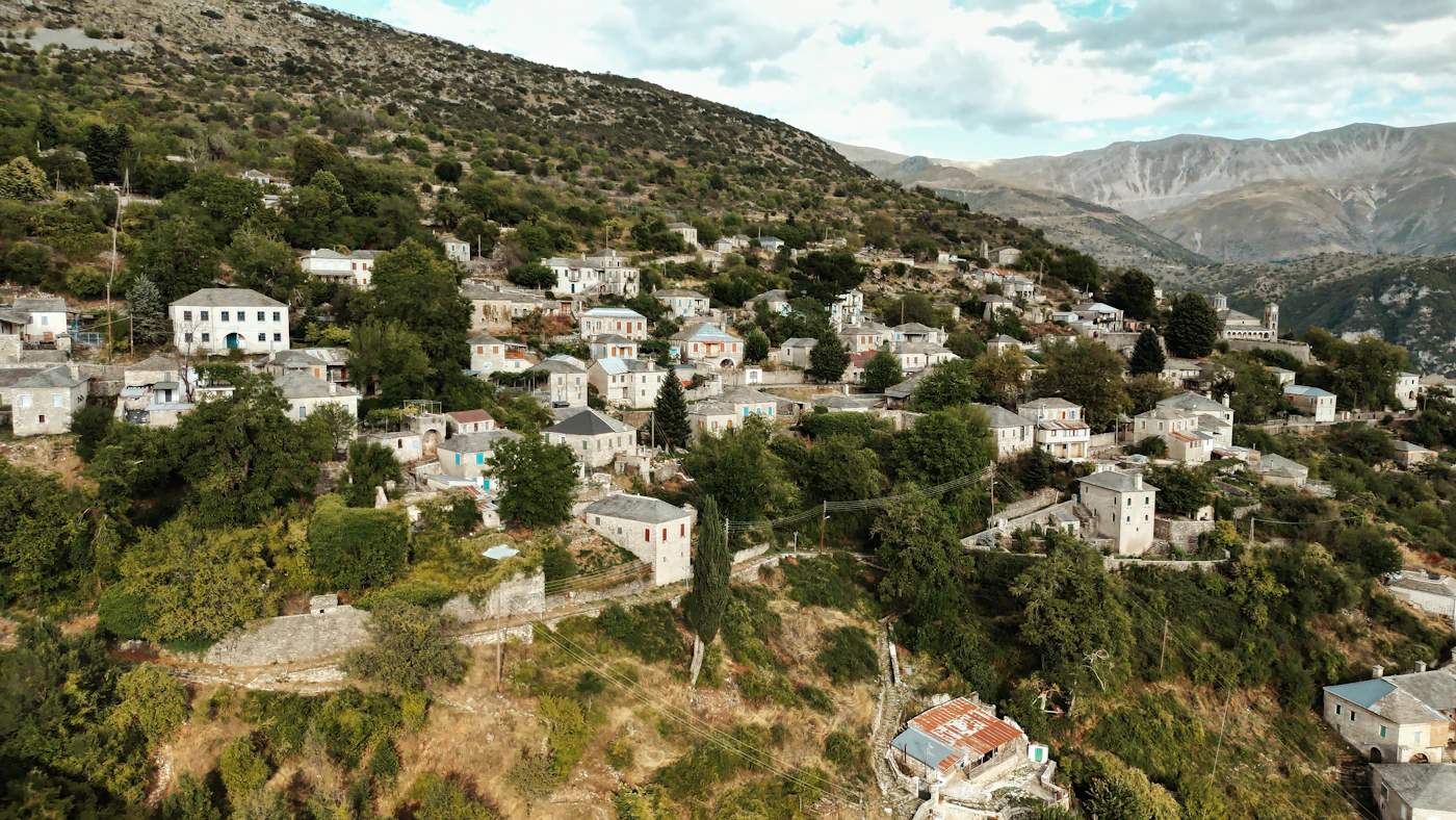 Πέτρινα σπίτια σε πράσινη πλαγιά