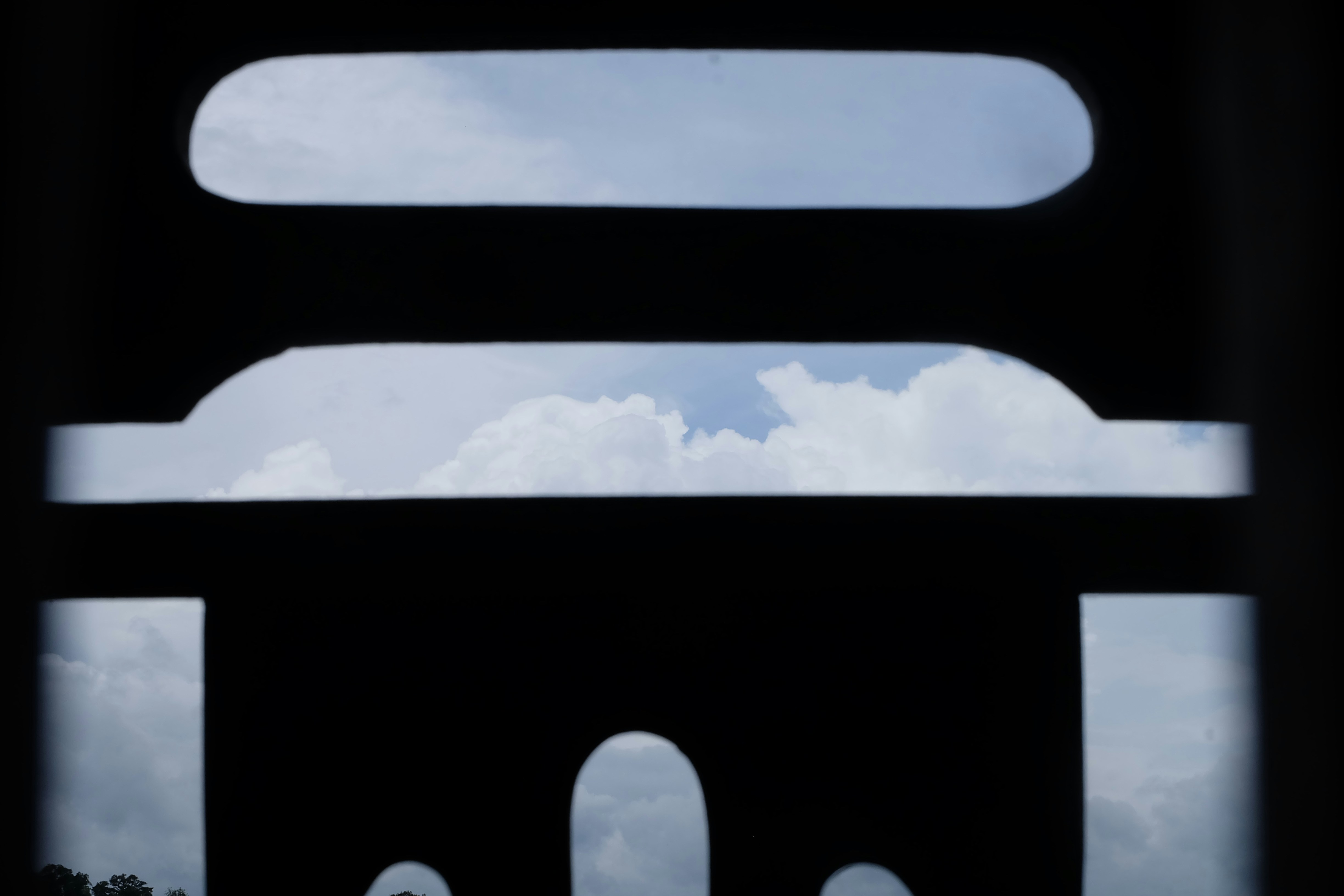 抽象的な暗い形を通して見える雲