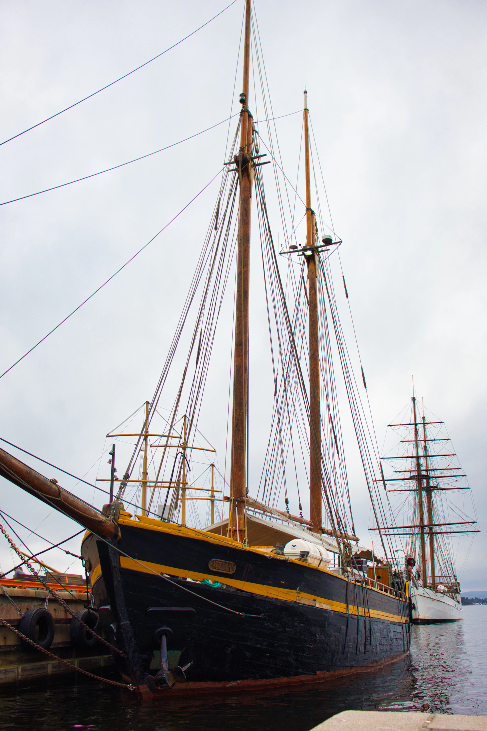 Two tall ships docked in a harbor