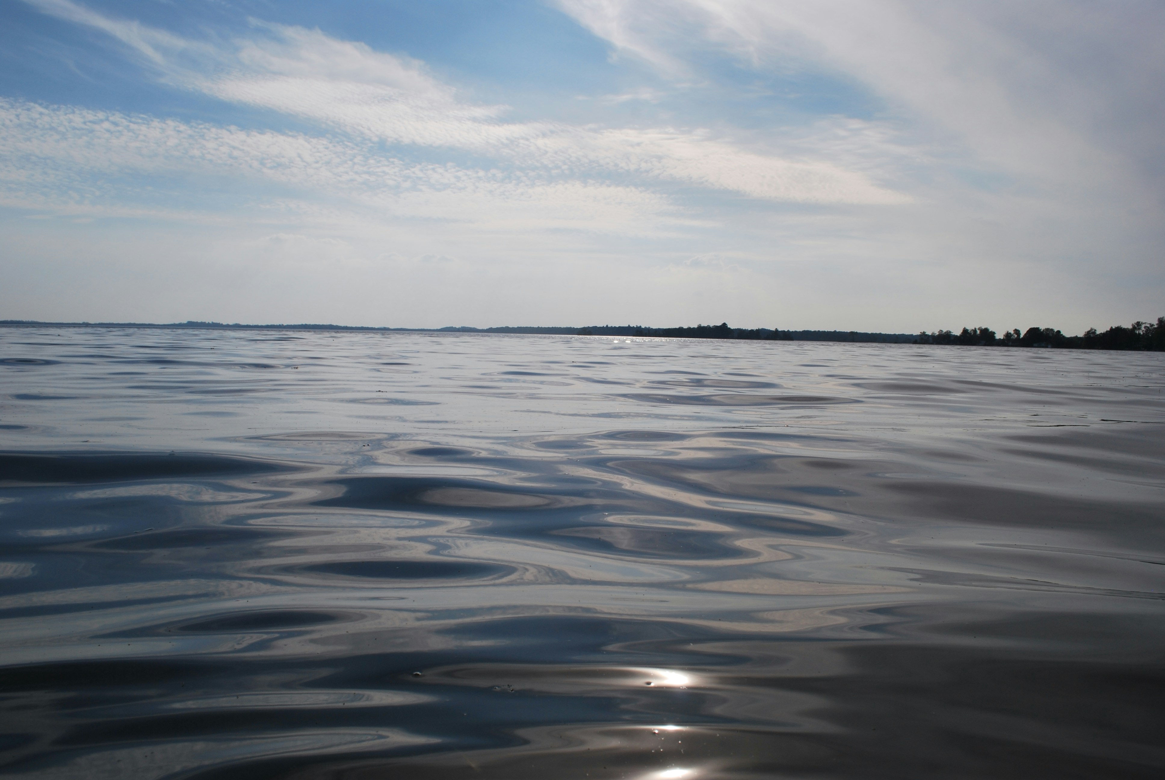 Calm water under a bright, cloudy sky