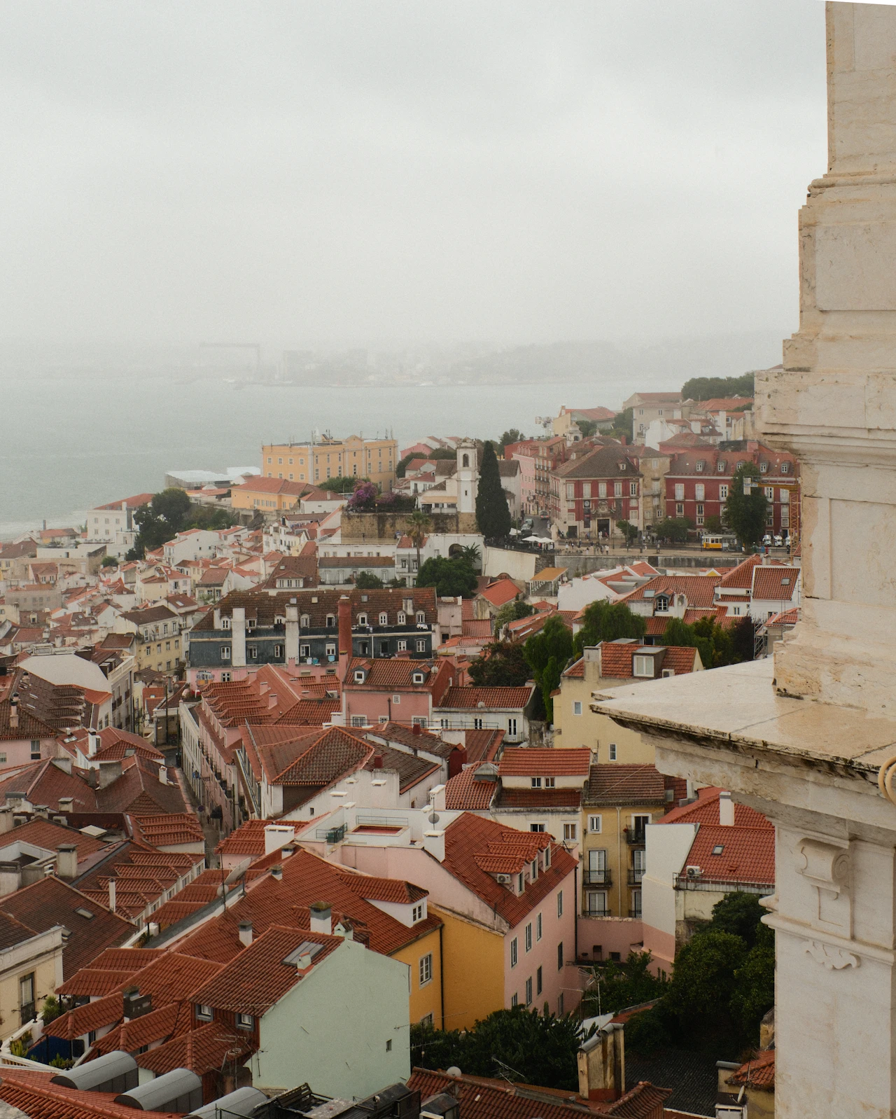 Misty rooftops of Lisbon's Alfama district overlooking the Tagus