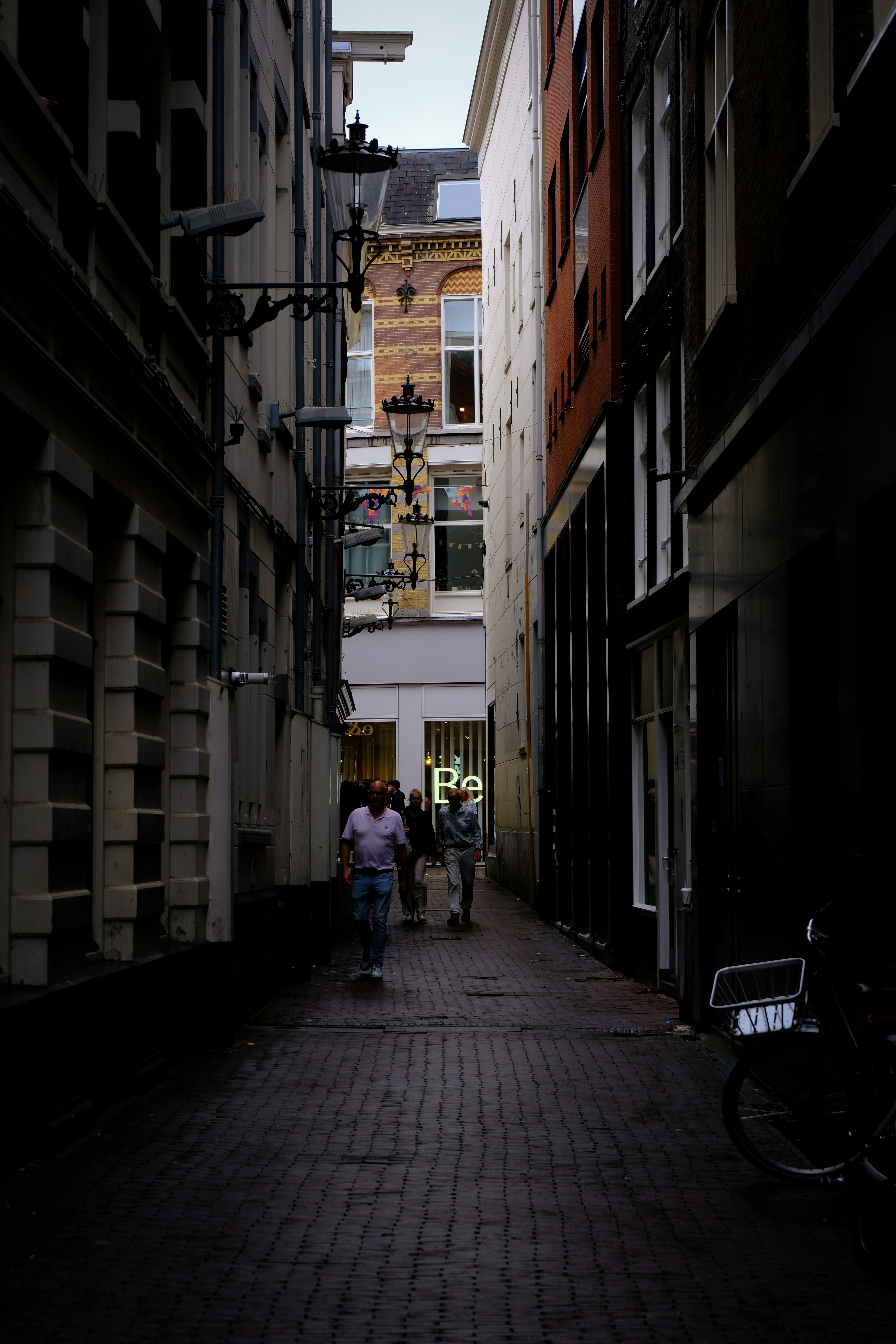 People walking down a narrow european street.