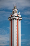 Citruc Tower with orange stripes against blue sky.