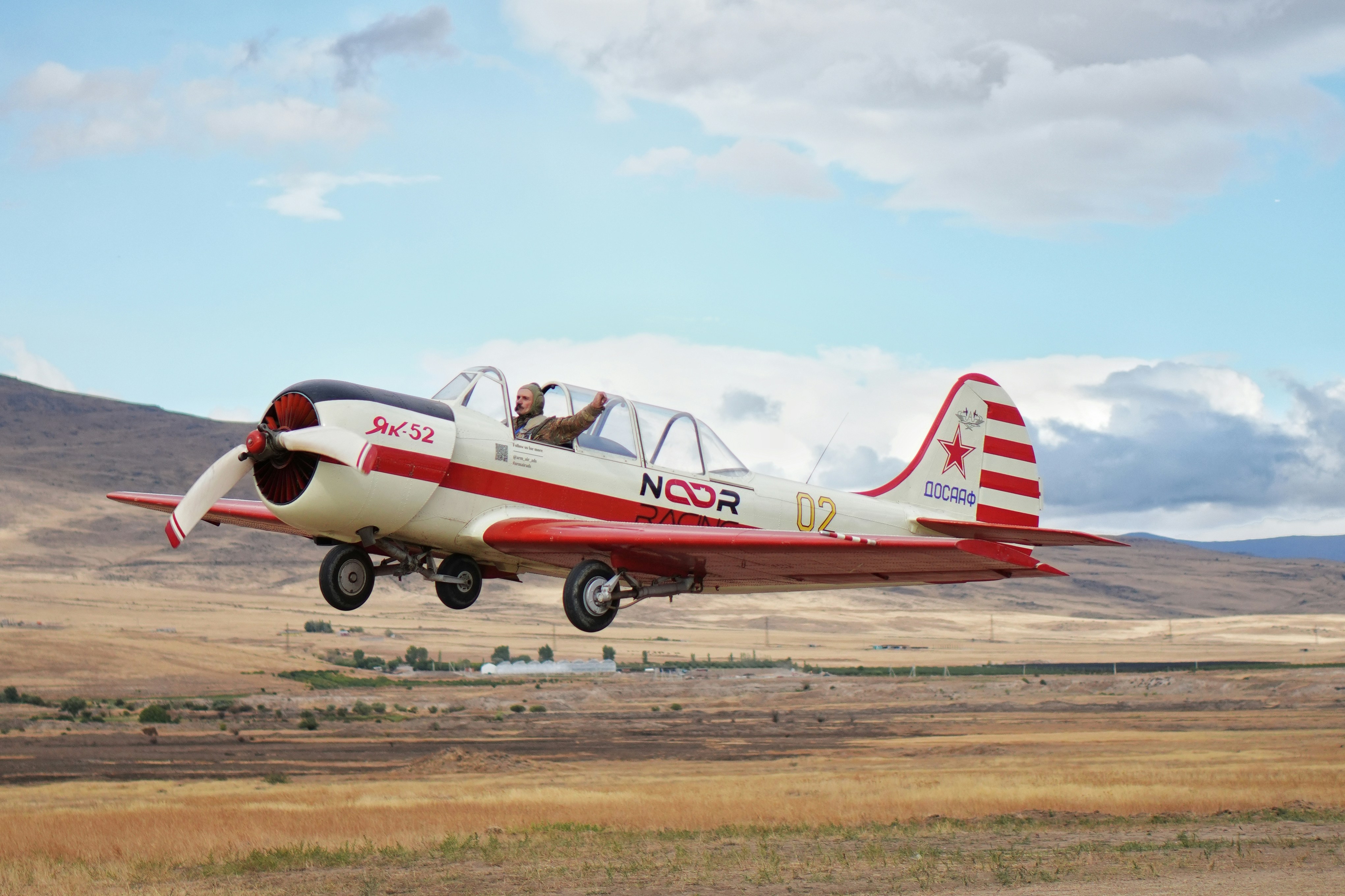 Vintage airplane taking off over a dry landscape