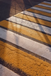 Yellow and white stripes of a crosswalk on asphalt