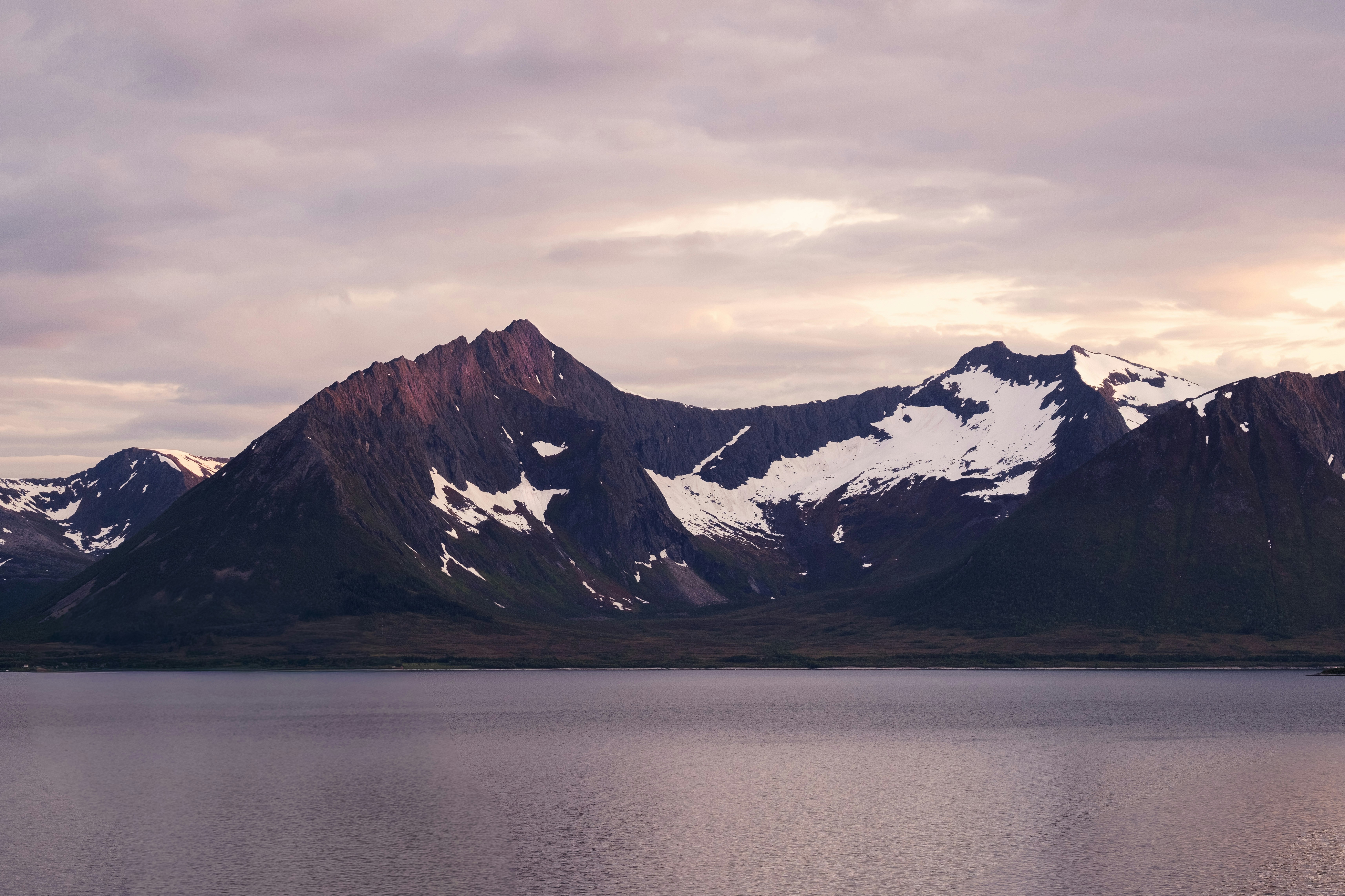 Snow-capped mountains rise above a calm lake