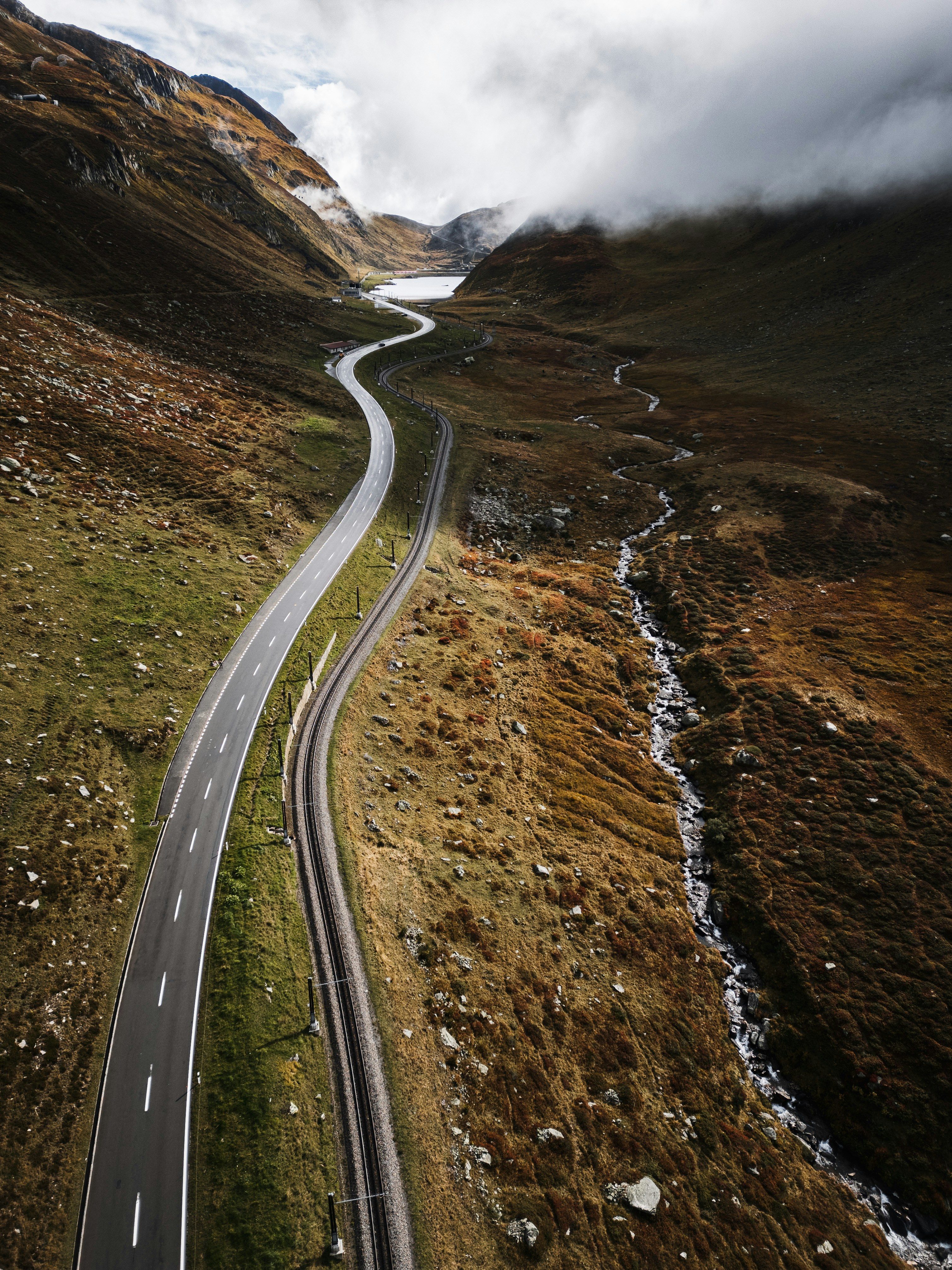 Winding mountain road next to a stream and stream.