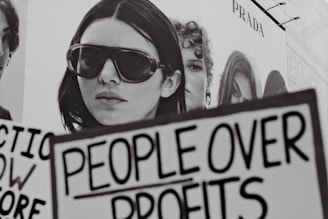 Woman holding sign people over profits