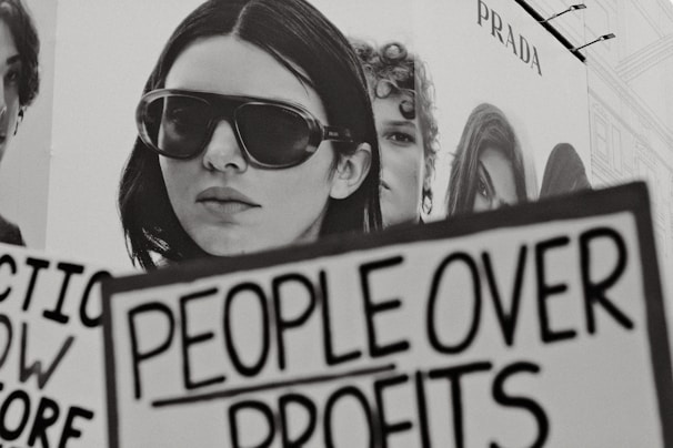 Woman holding sign people over profits