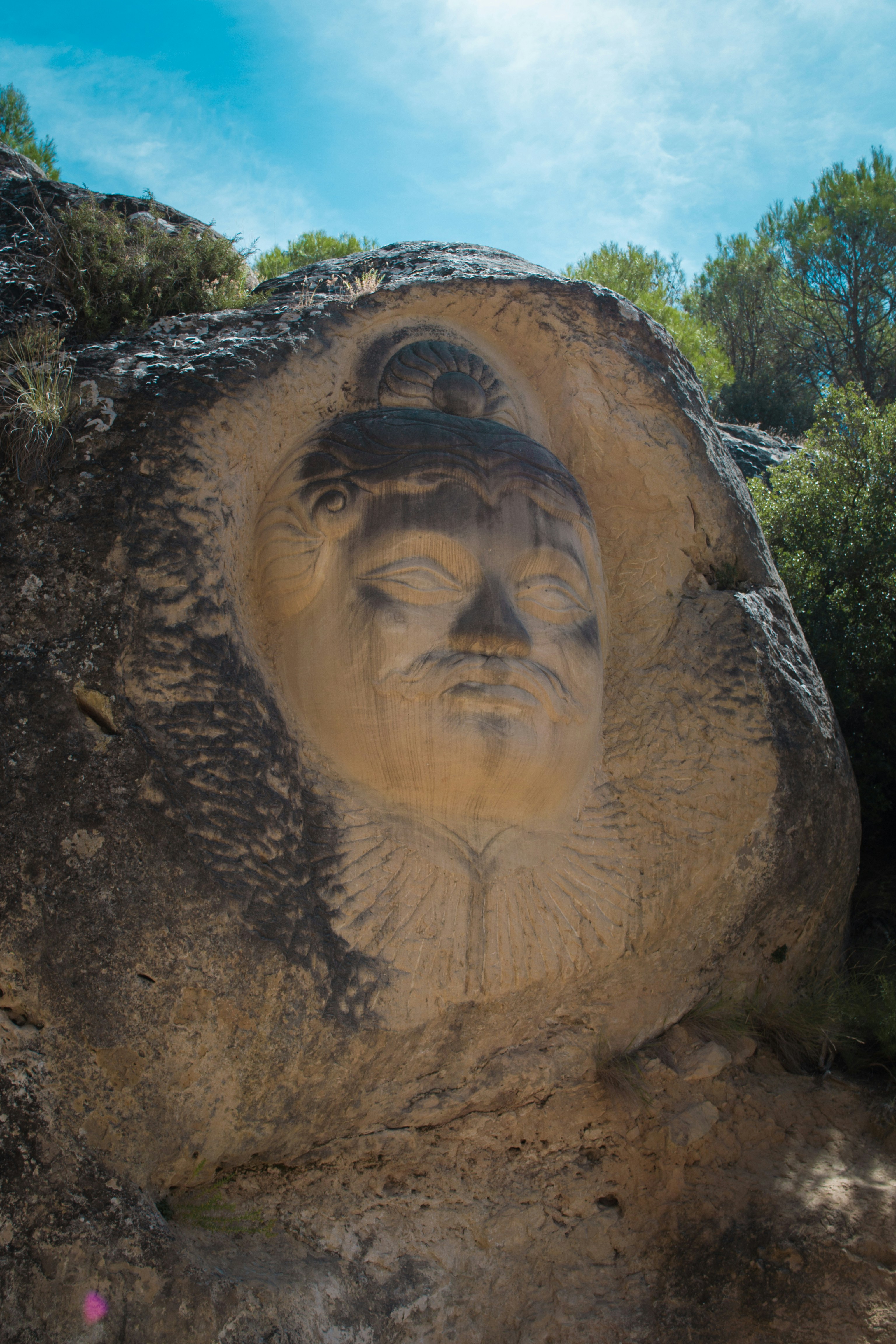 Talla de una cara en un acantilado rocoso al aire libre