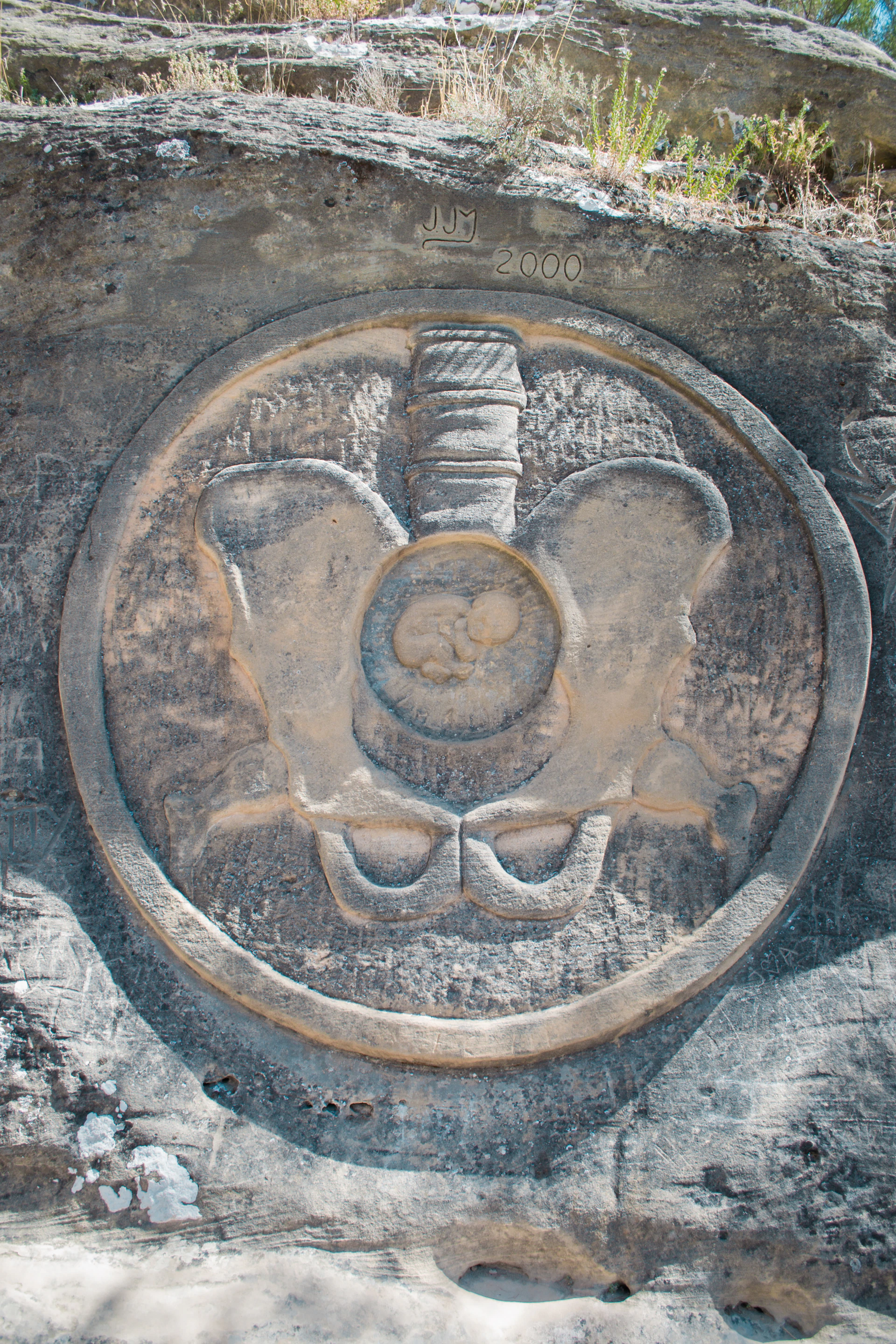 Stone carving of a pelvis with fetus inside