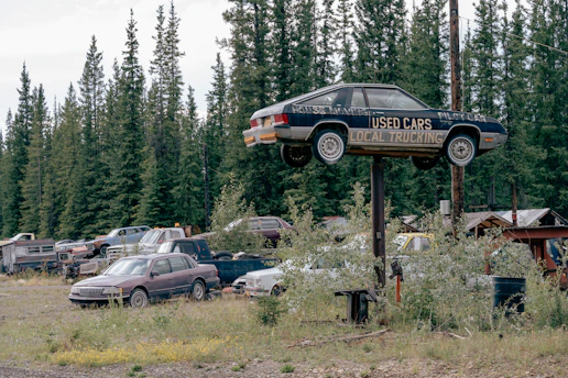 Used car mounted on pole above junkyard