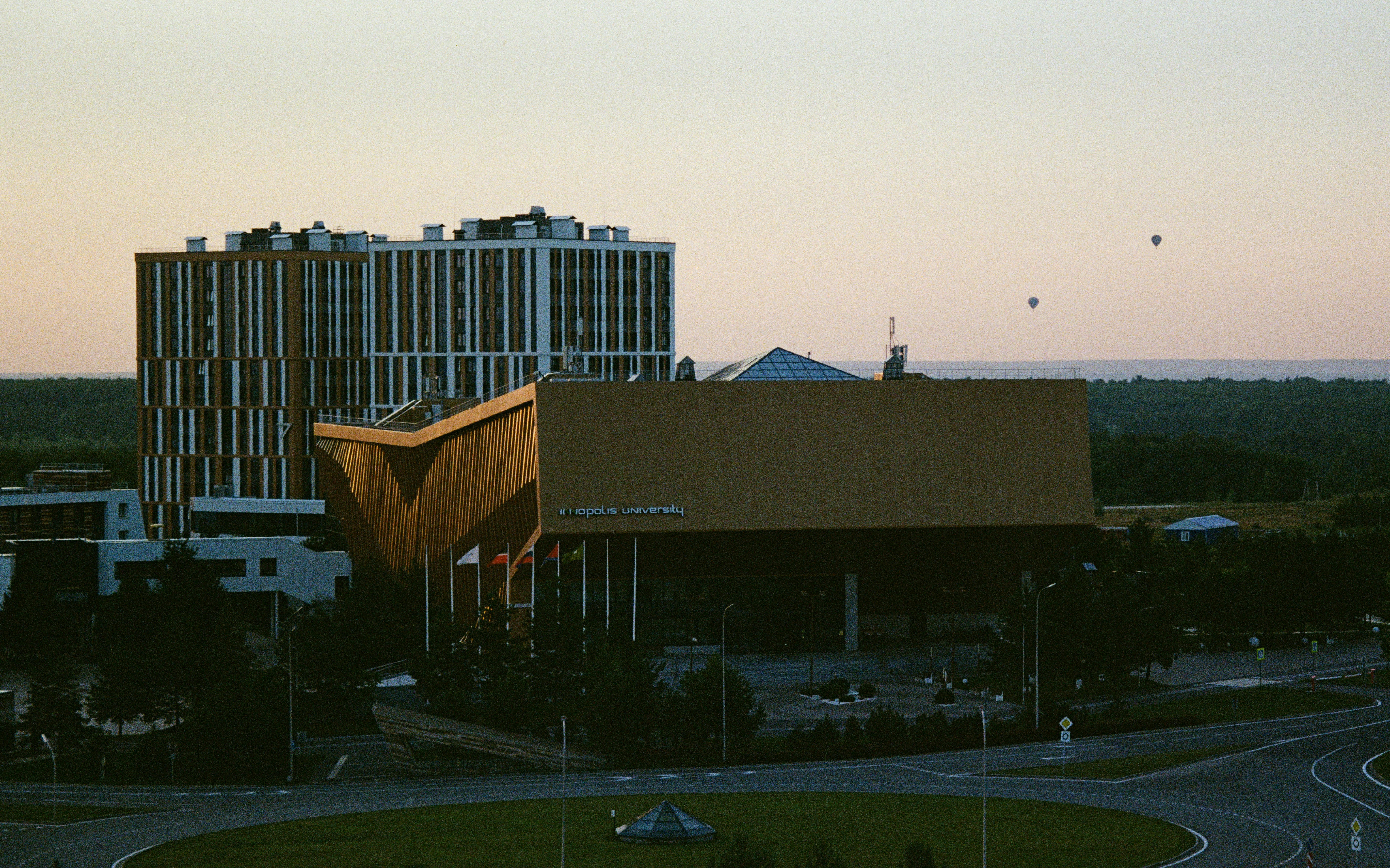 Modern buildings against a pale sky at dusk.