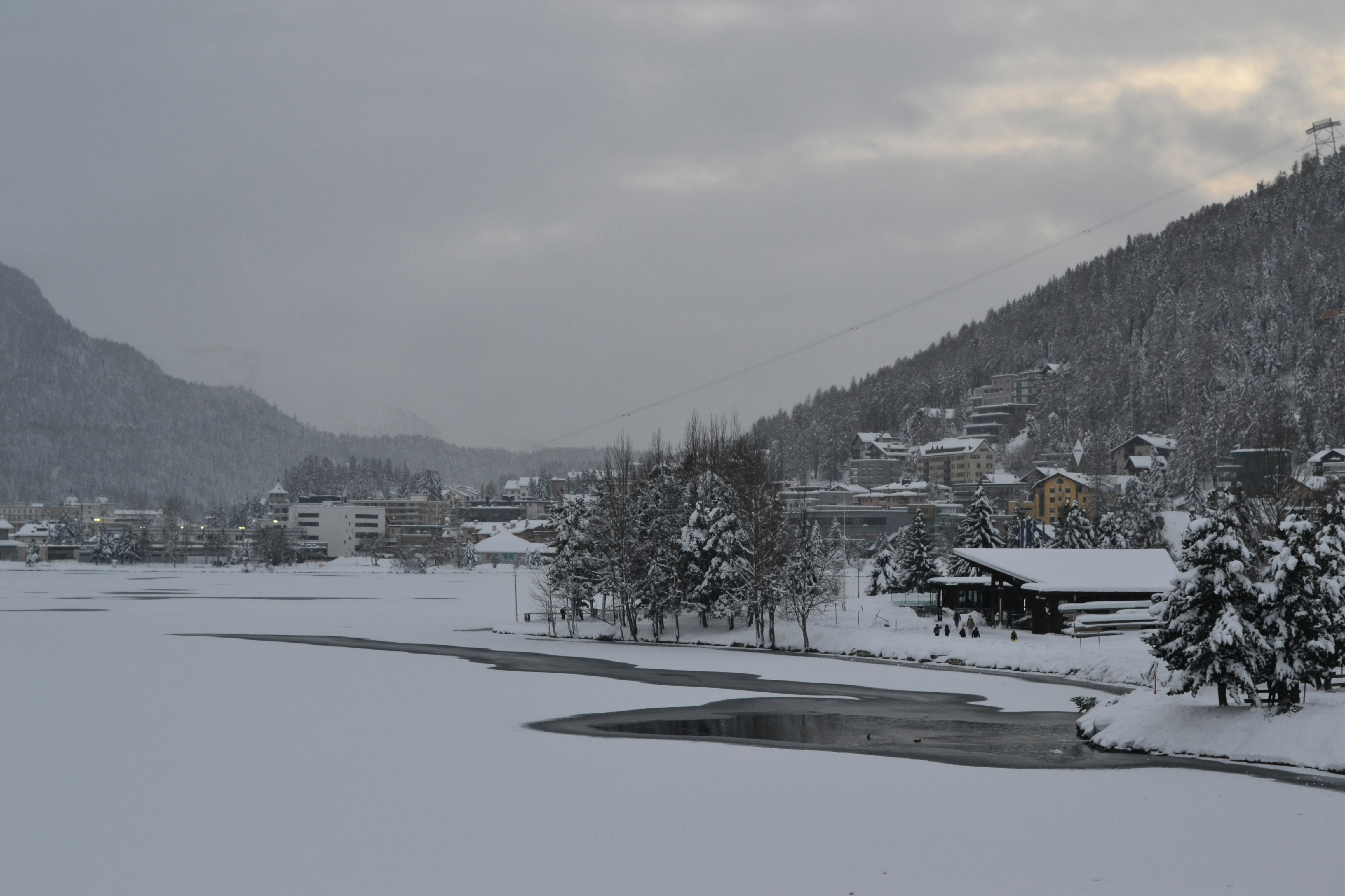 Snowy landscape with a frozen lake and distant mountains