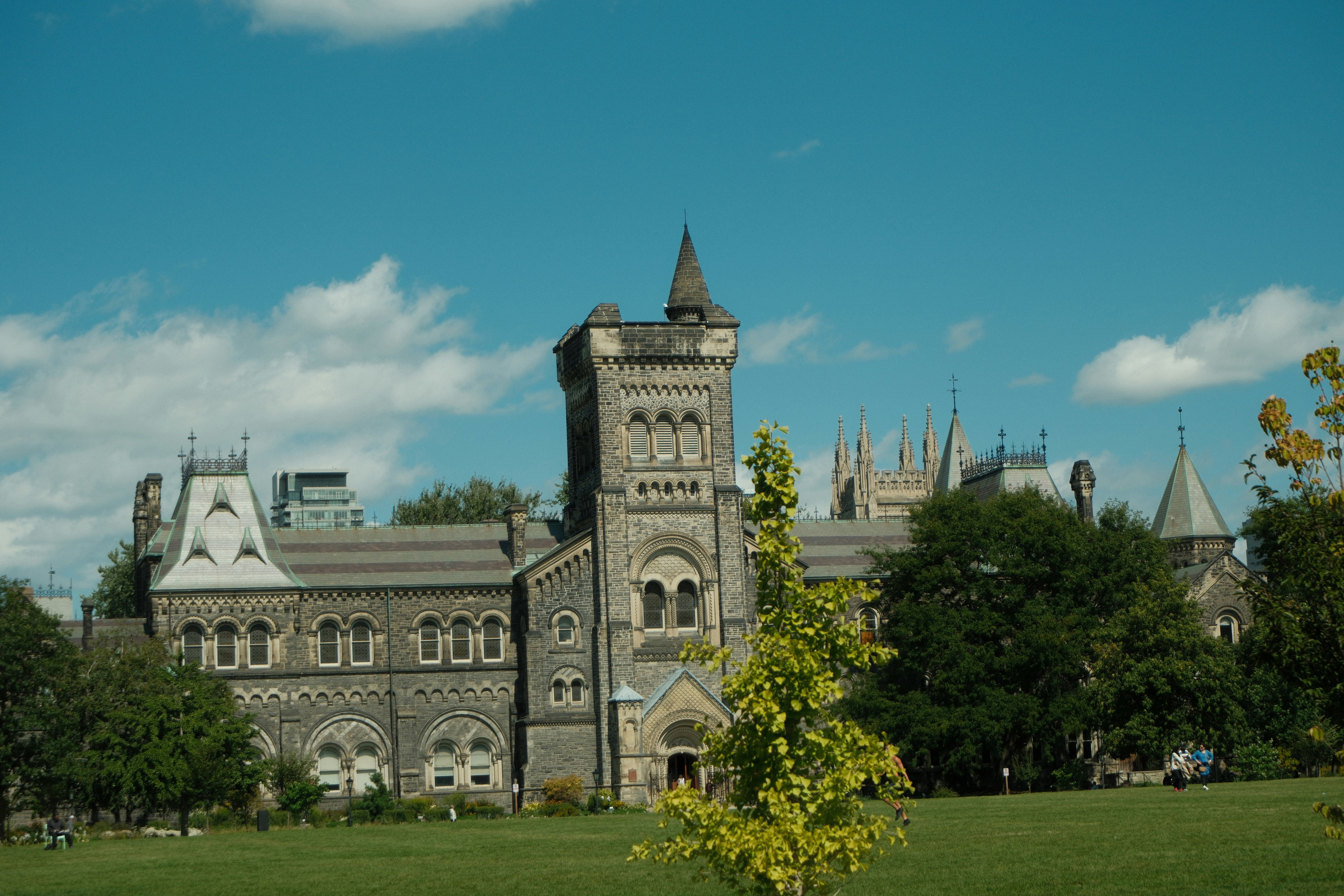 Historic stone building with gothic architecture and green lawn.