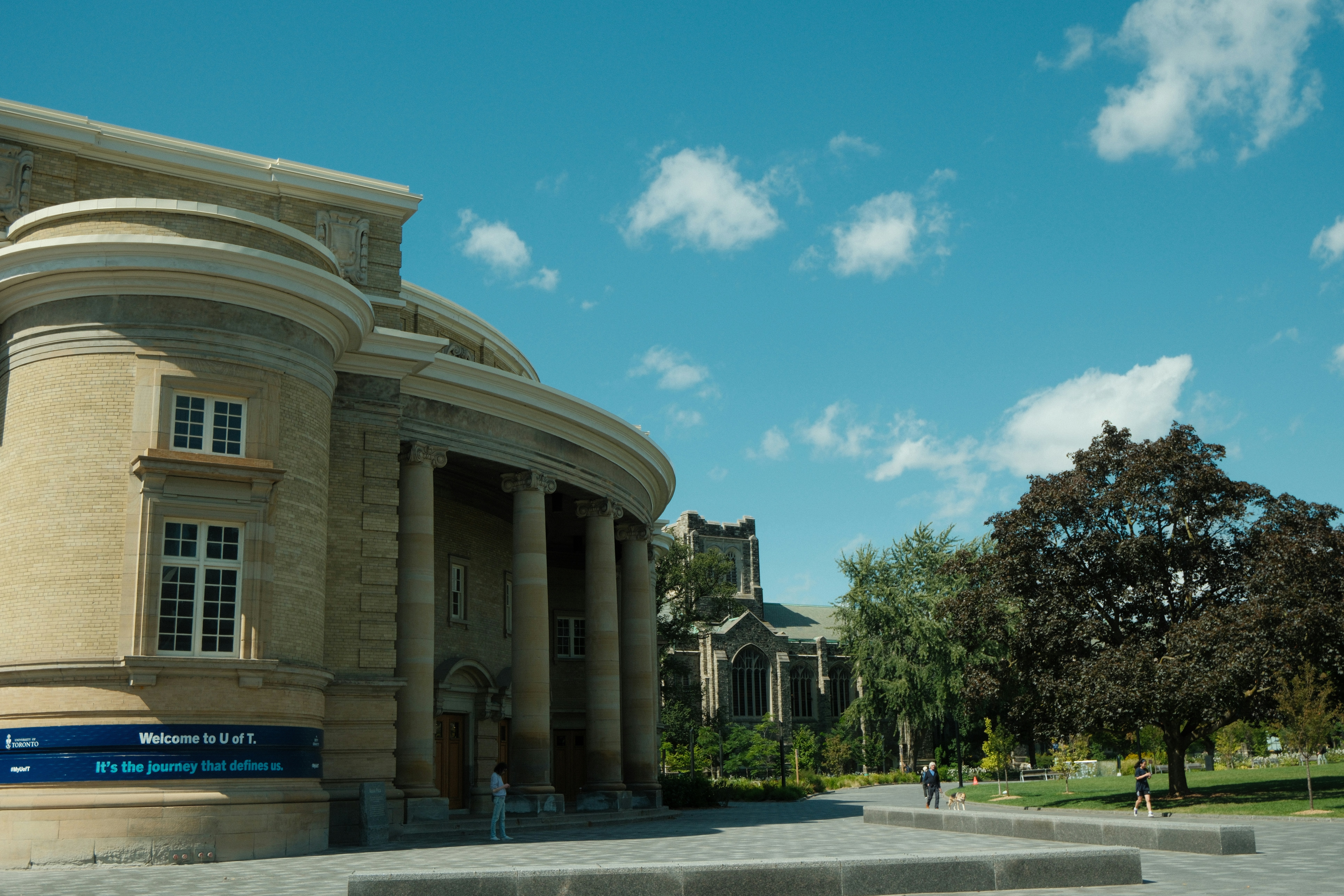 Grand building with columns and trees under blue sky.