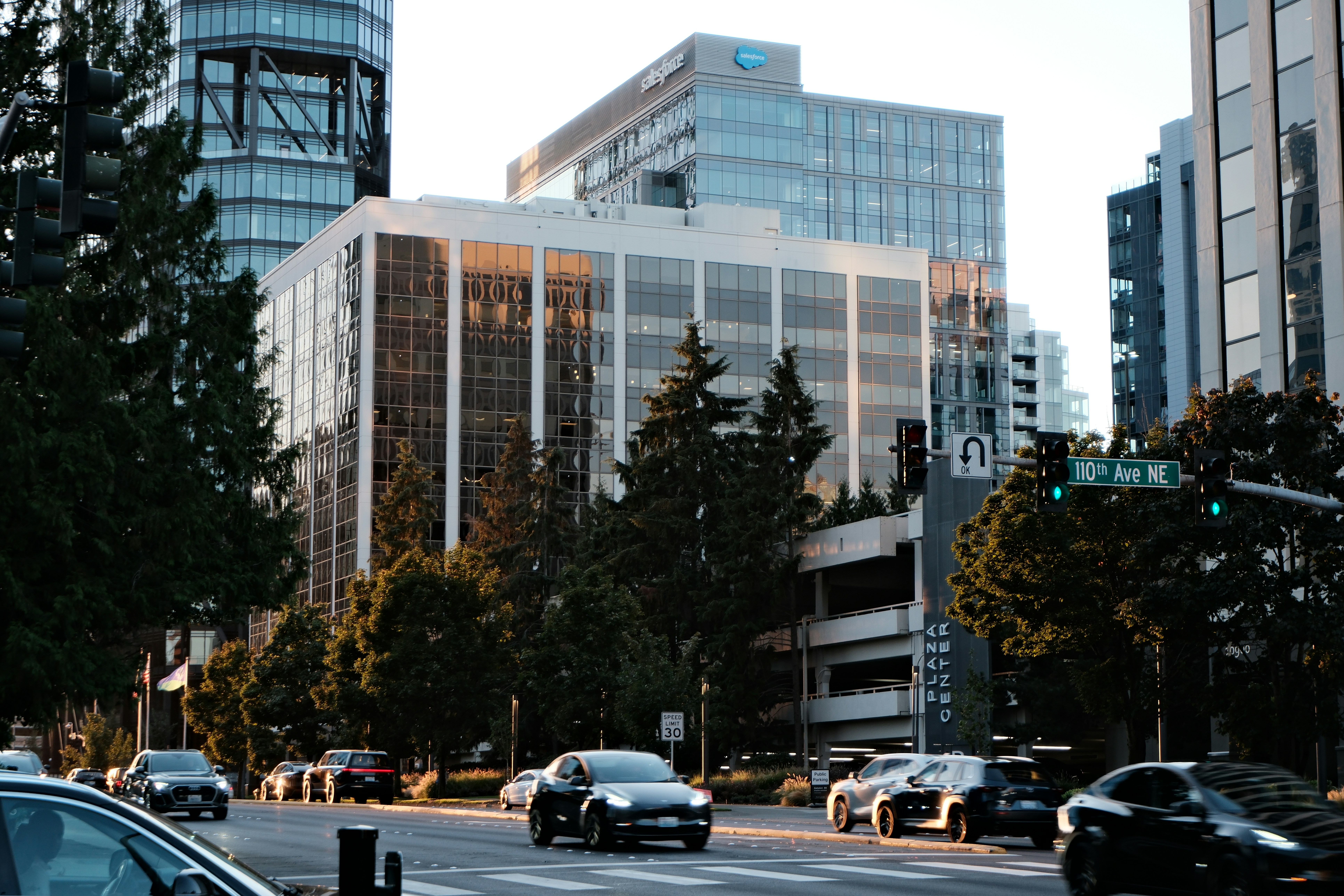 Cars driving on a city street with modern buildings.