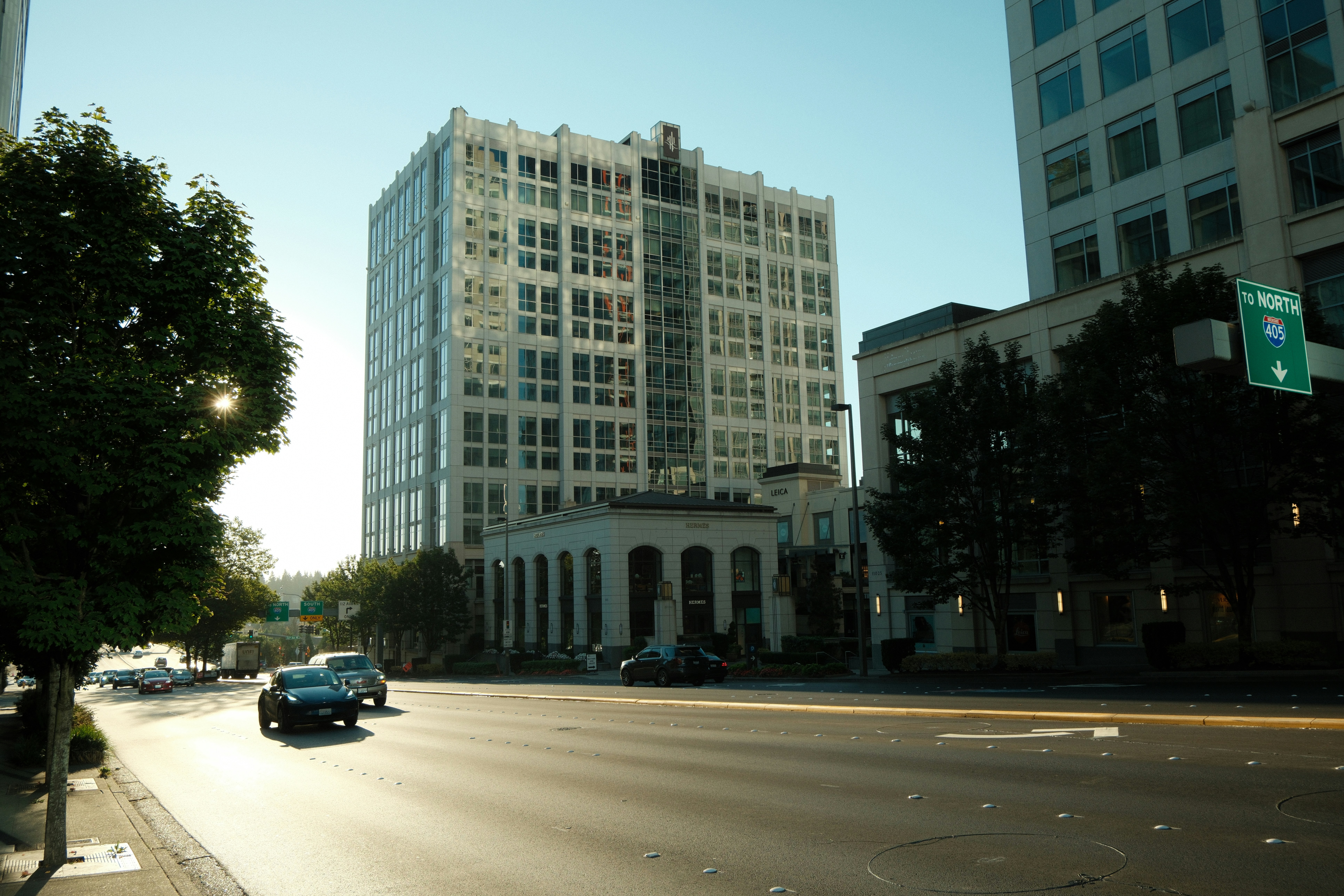 Tall white building on a sunny city street.
