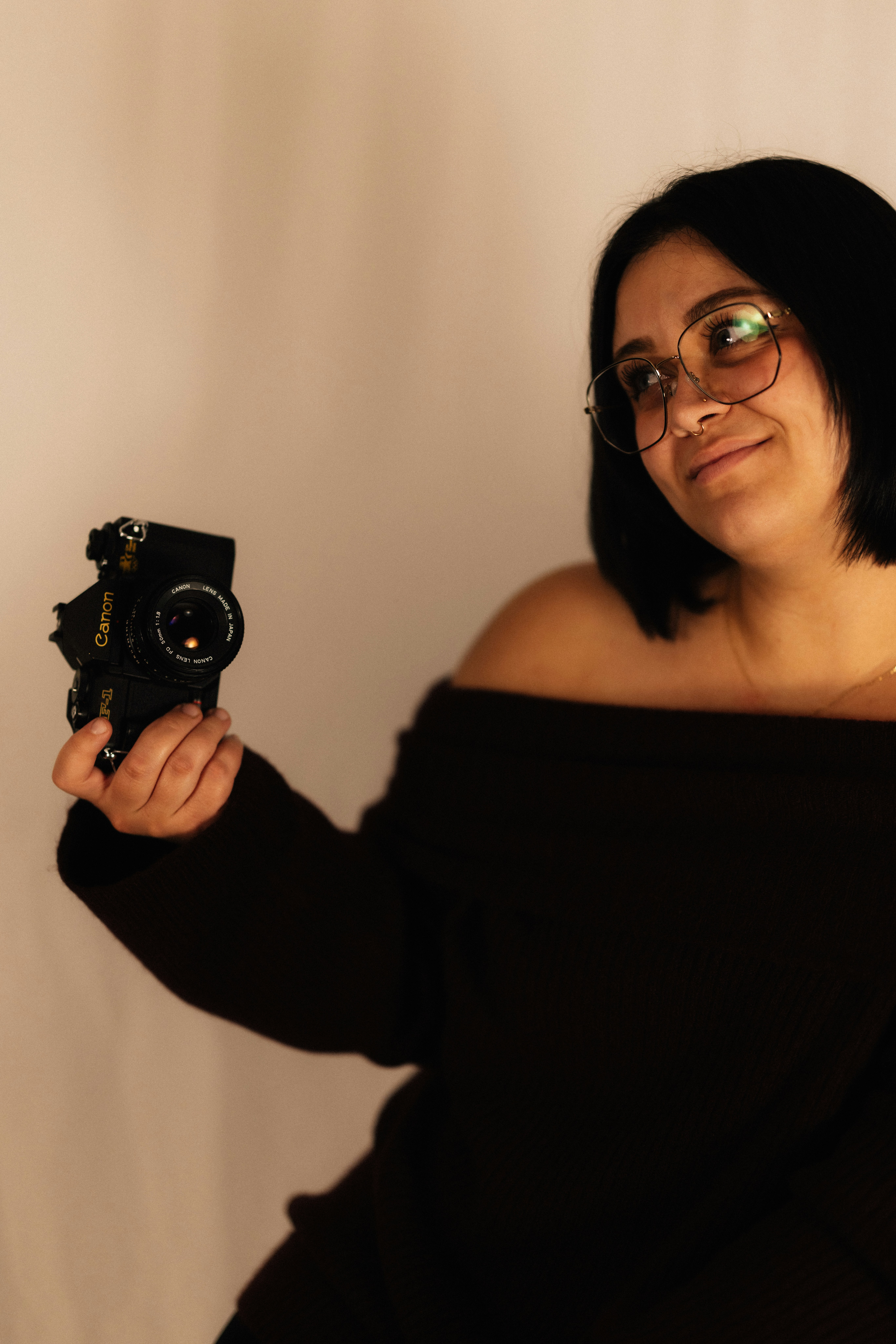 Mujer sosteniendo una cámara vintage con gafas