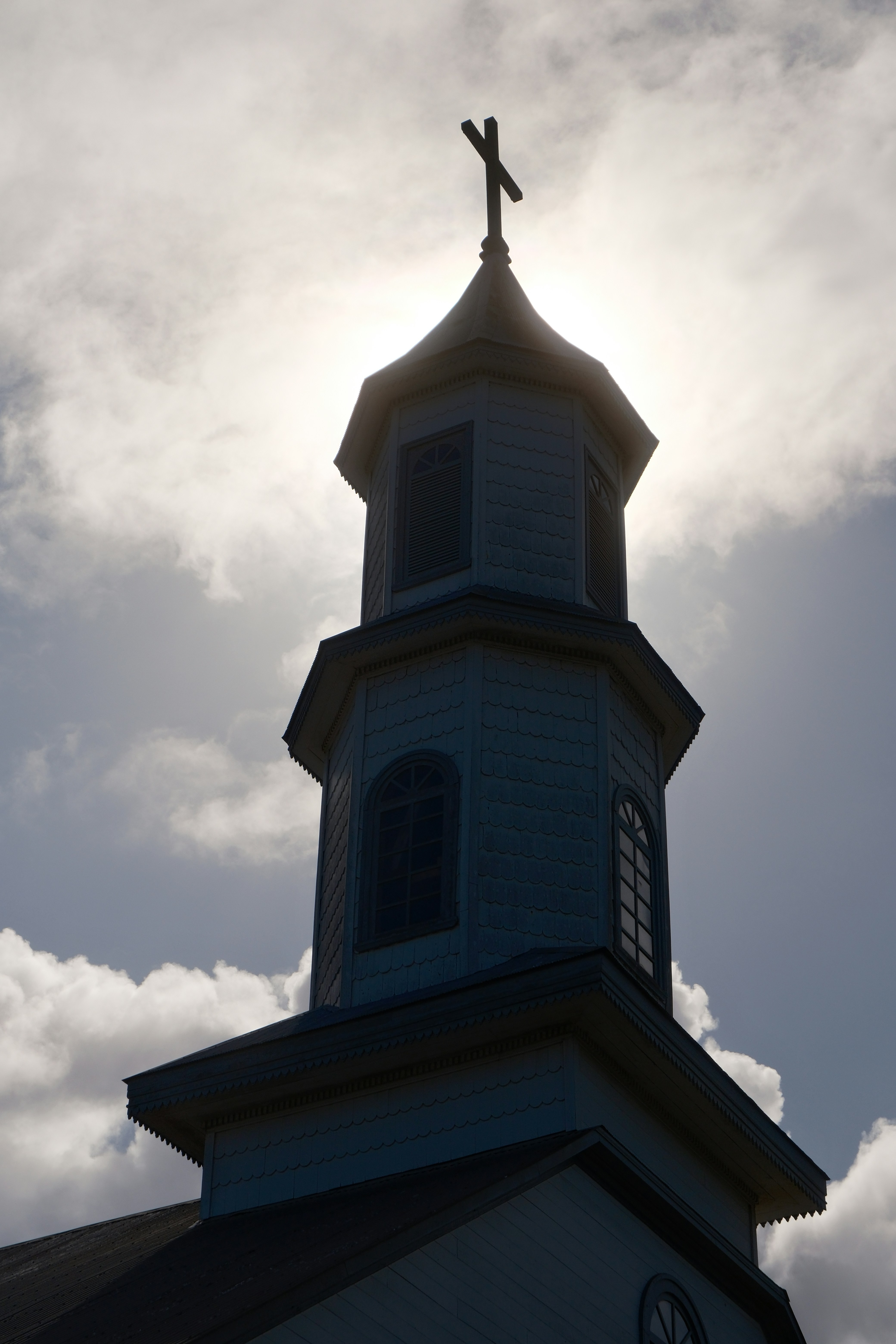 Church steeple silhouetted against a cloudy sky