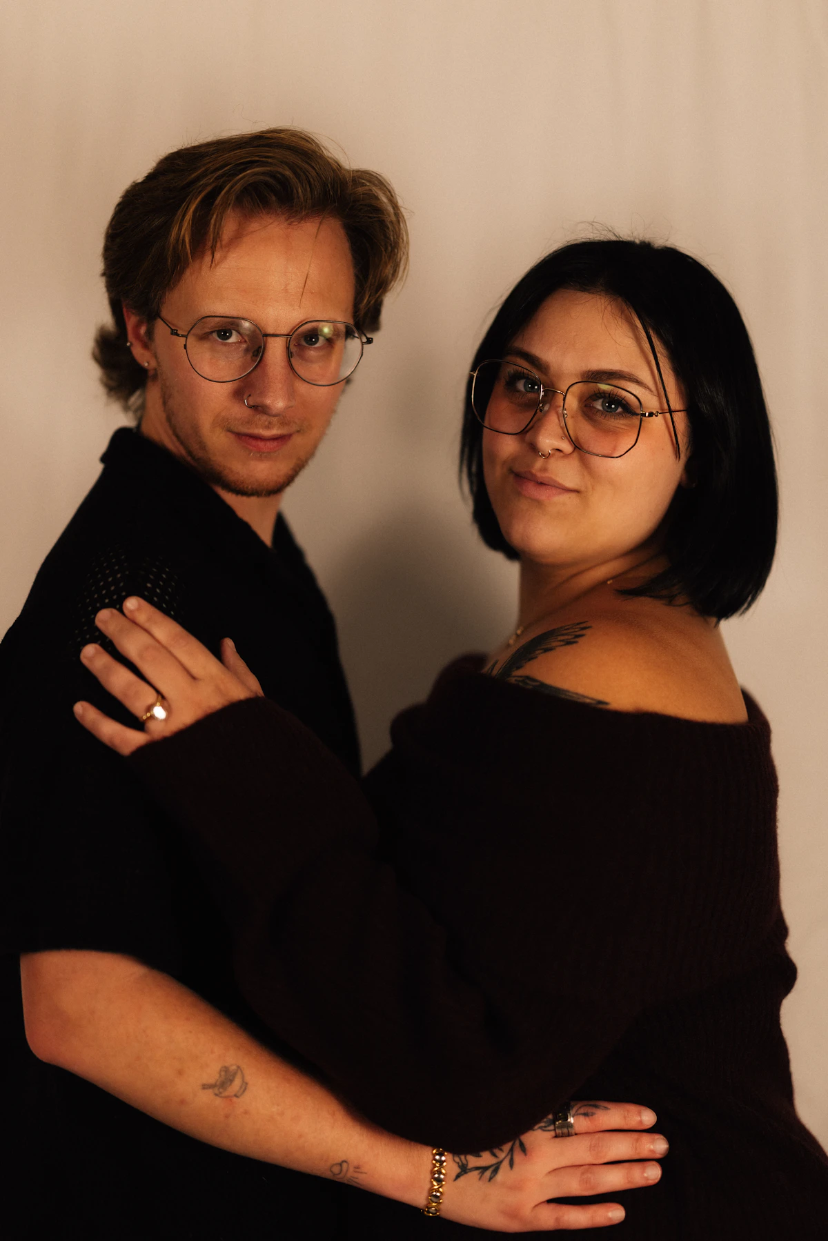 Couple posing together for a studio portrait against a neutral background.