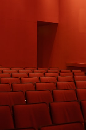 Sièges rouges de cinéma dans une salle sombre