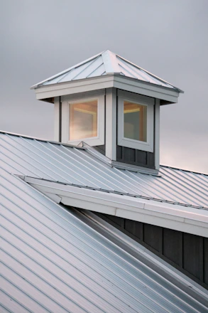 Modern barn roof with cupola and cloudy sky
