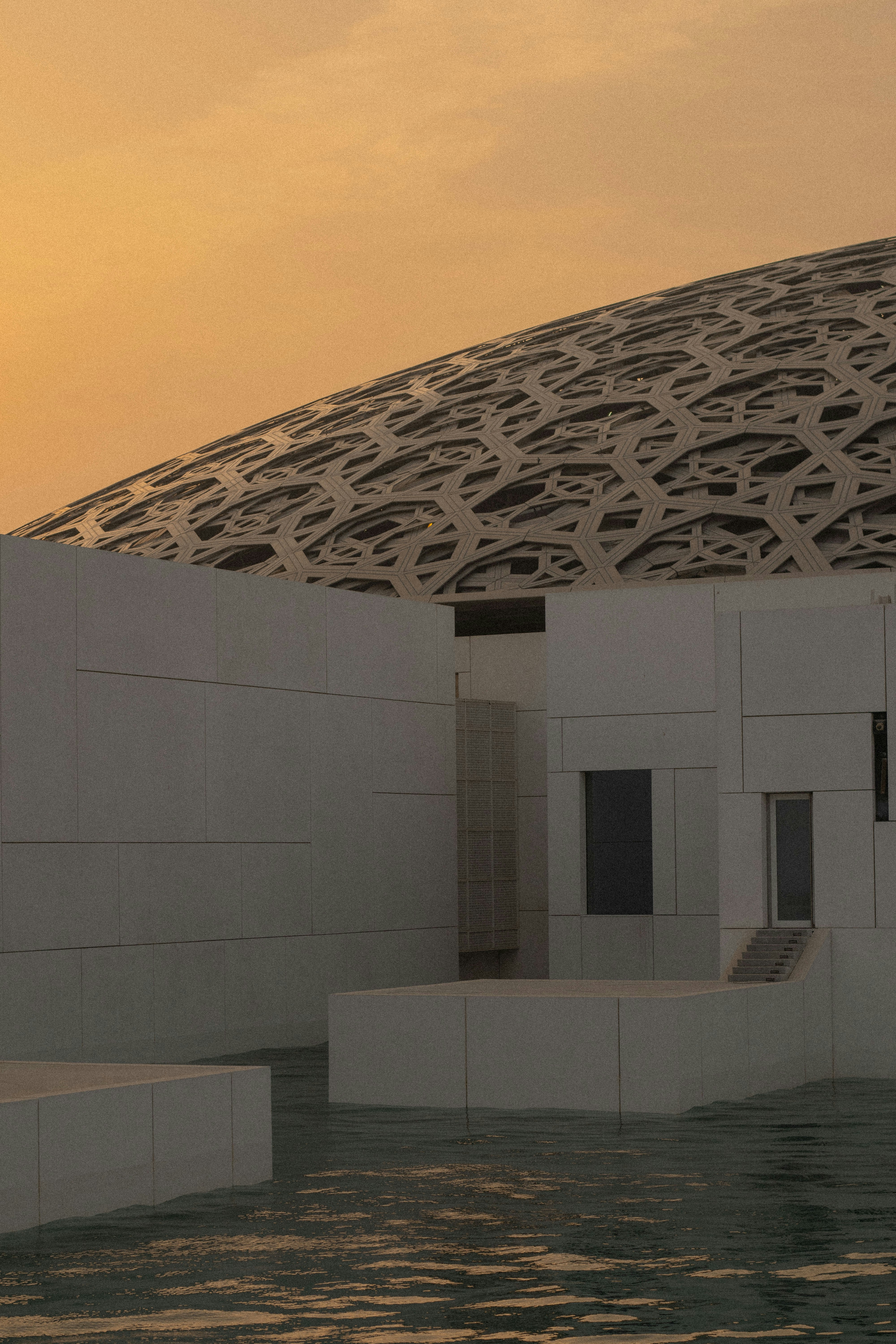 Arquitectura moderna con agua y cielo al atardecer