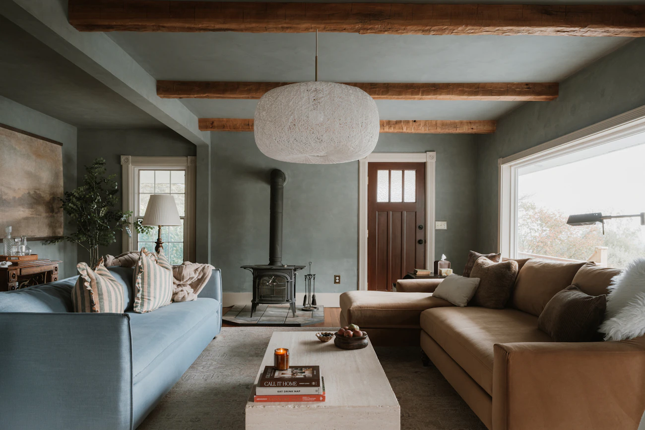 Warm residential living room with comfortable sofa, books, natural textures, and inviting furnishings
