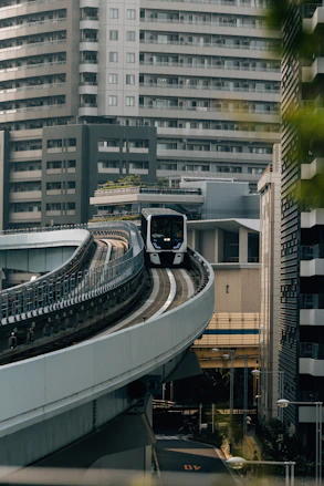Modern train on elevated tracks in a city.