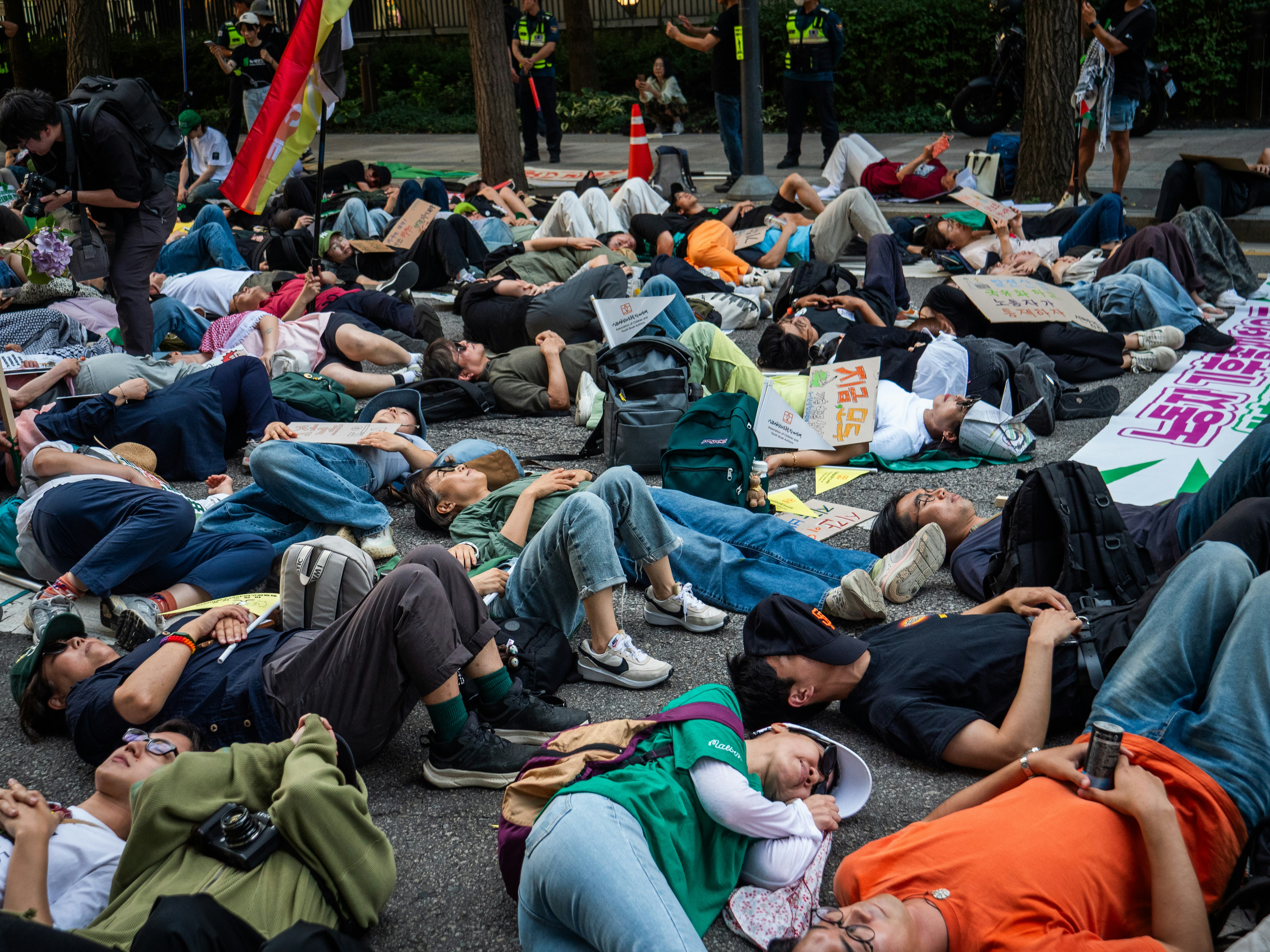 Protesters lie down on a street during a demonstration.