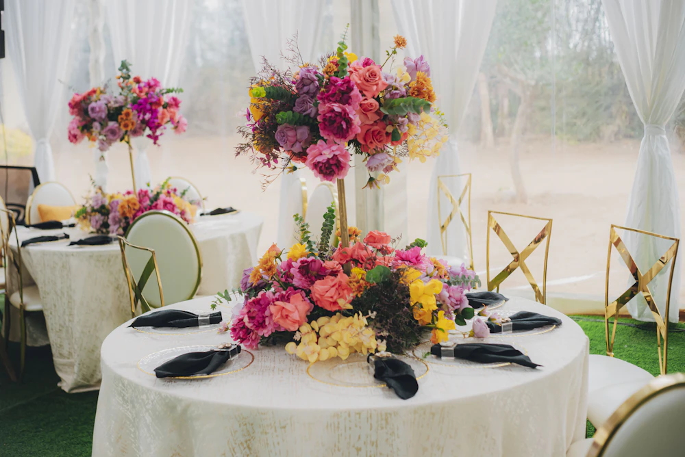 Réception raffinée avec nappes claires et bouquets aux teintes rose et grenat