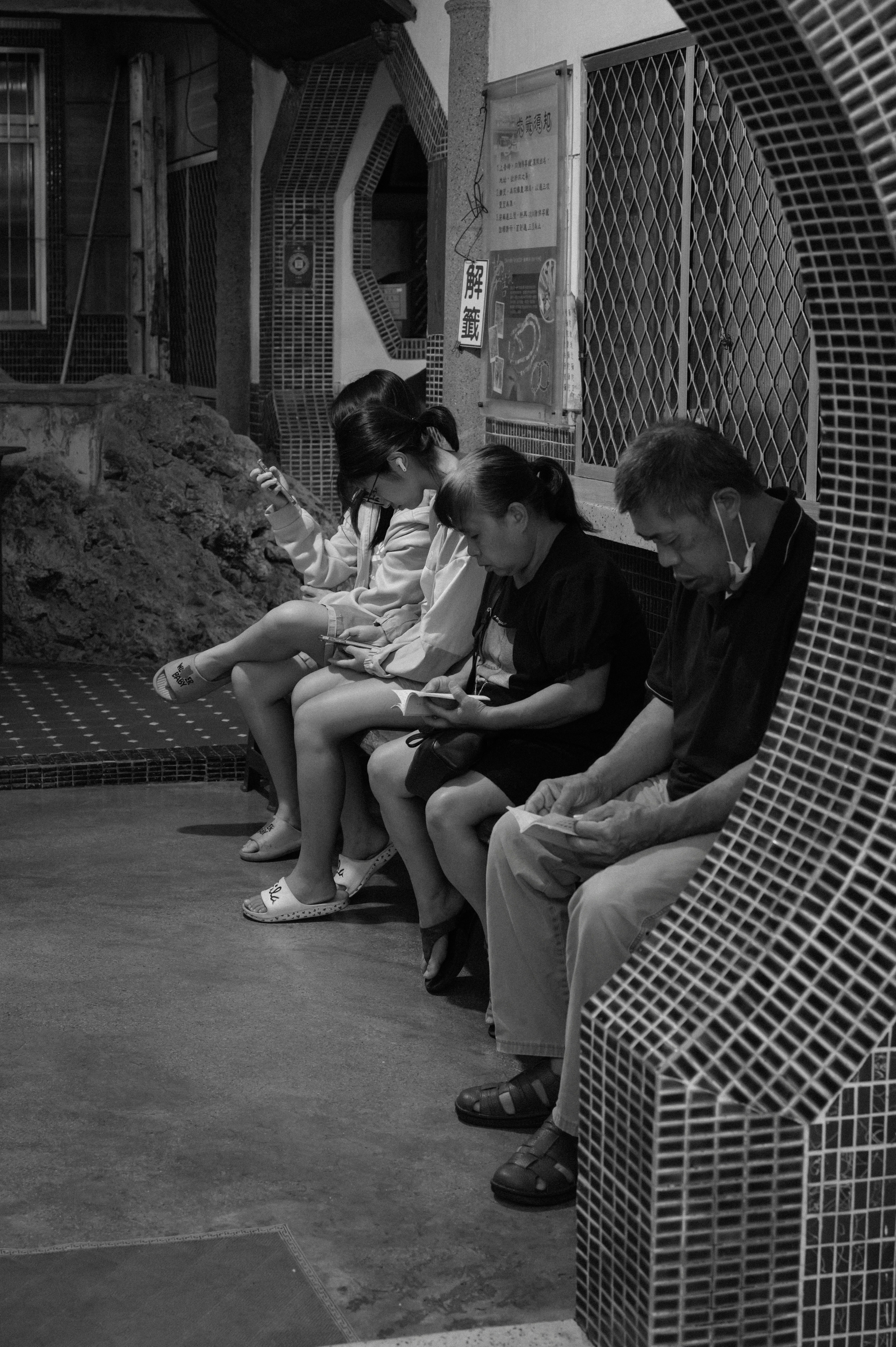 People sitting in a row looking at their phones.