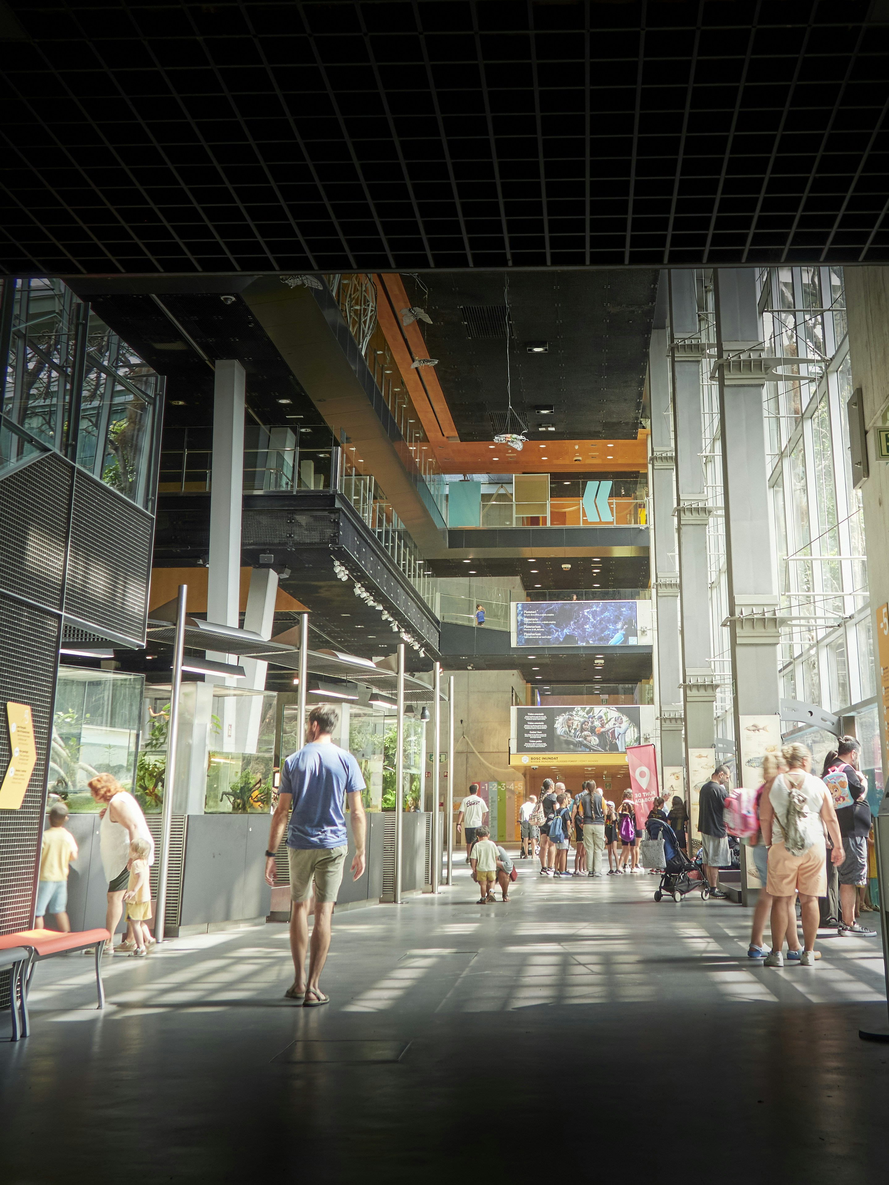 People walking through a modern, multi-level building interior.