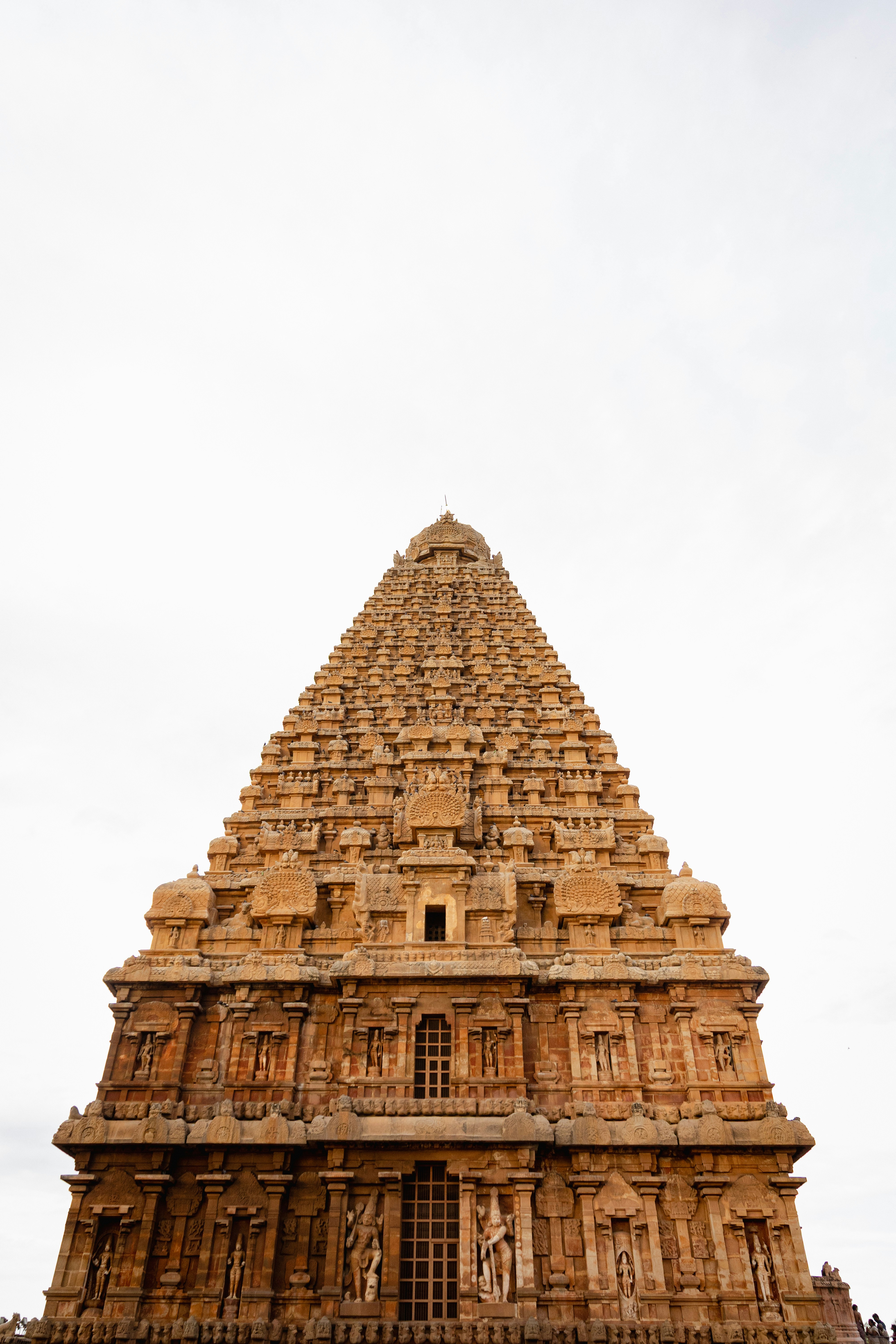 Torre de templo antiguo ornamentada contra un cielo blanco