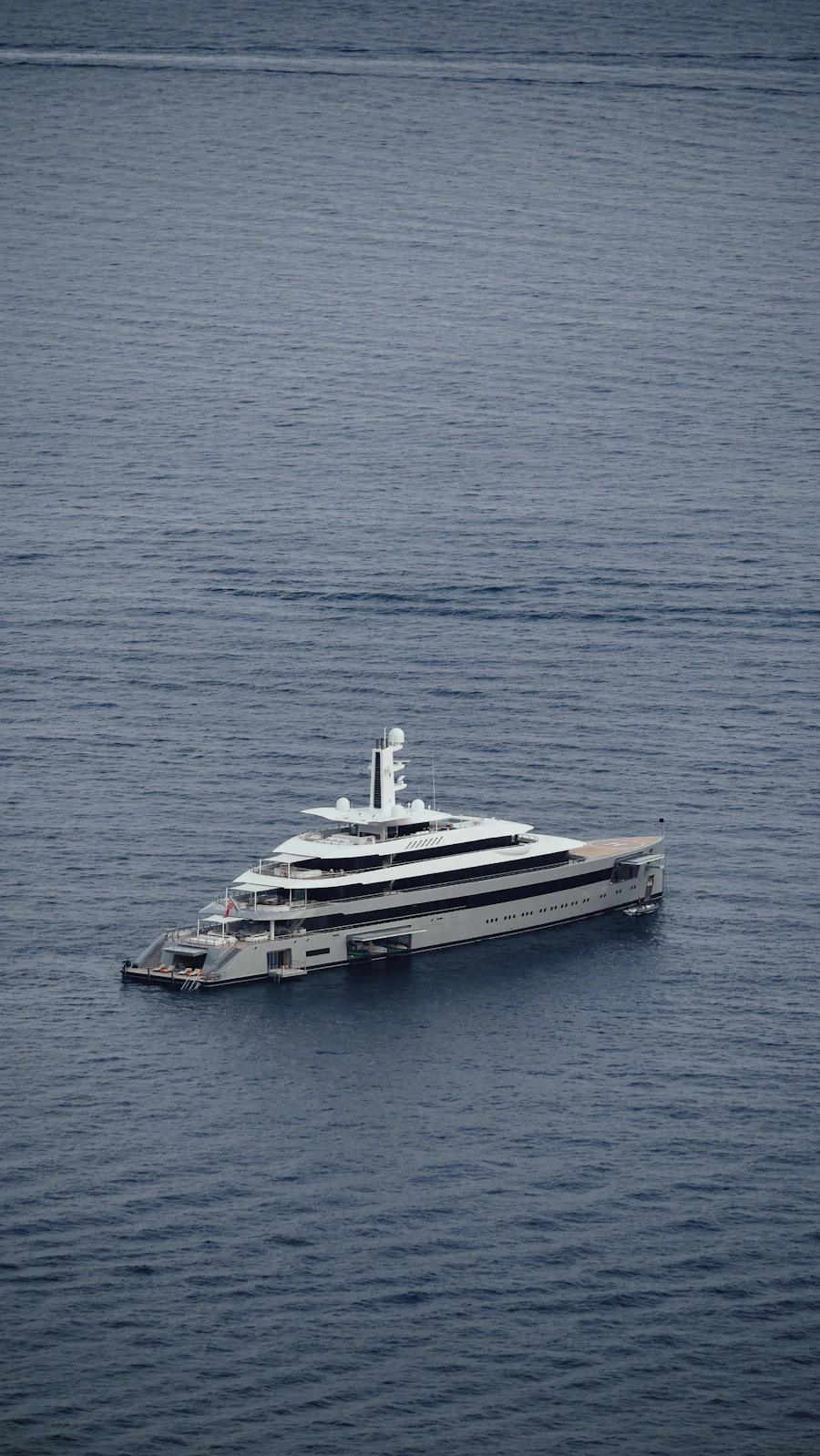 A very large yacht seen from above on grey open water.