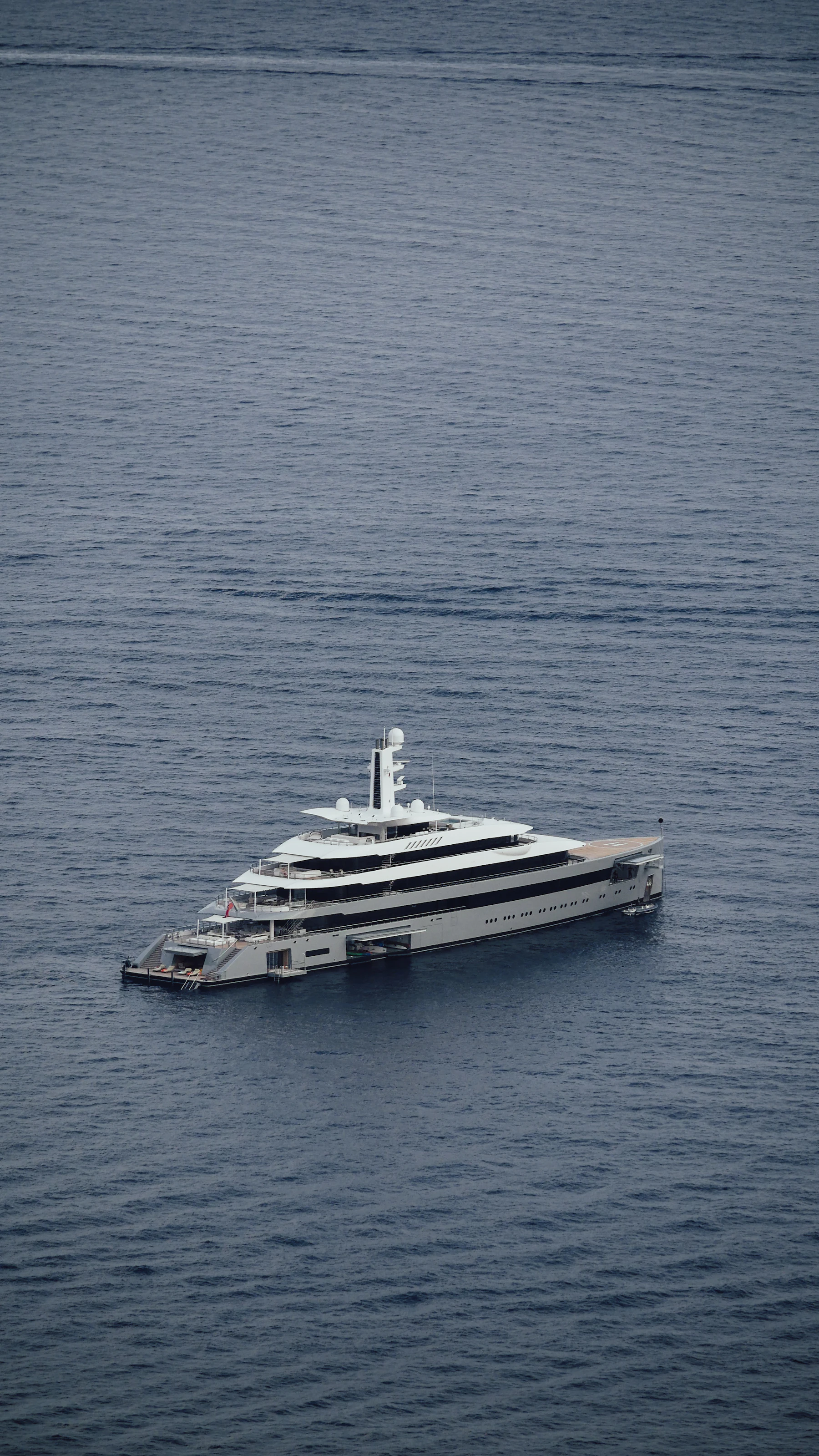 A very large yacht seen from above on grey open water.