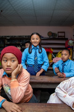 Children in a classroom wearing school uniforms.