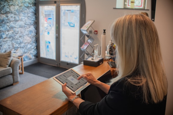 Woman using a tablet at a reception desk.